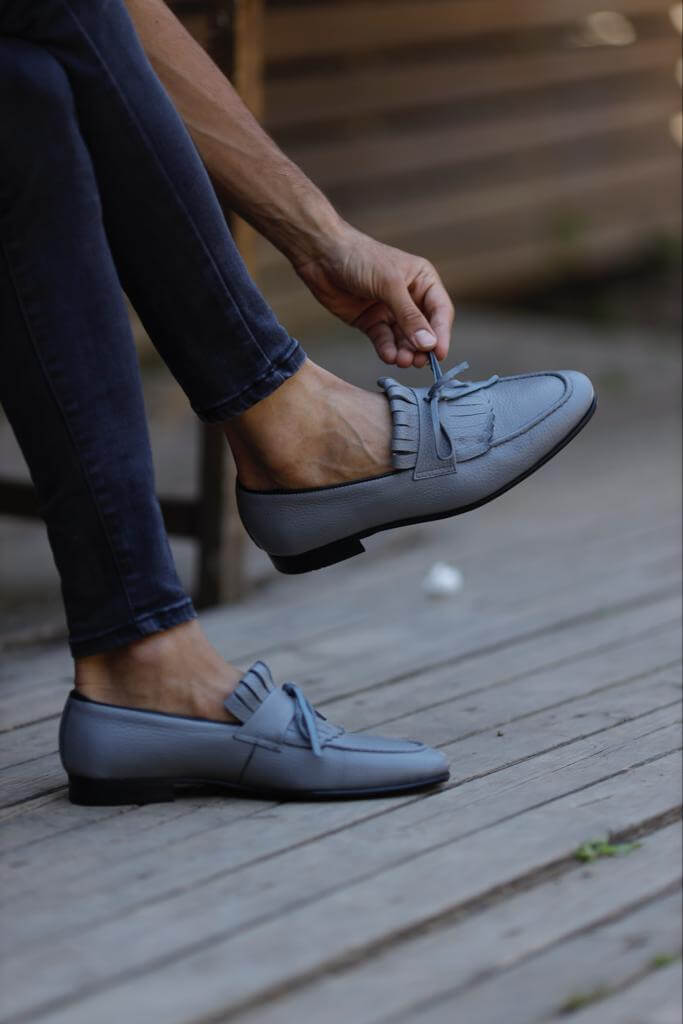 Grey patent leather loafers with unique rope detailing and a sleek neo-lite sole, photographed in a studio setup for modern spring-summer menswear inspiration.