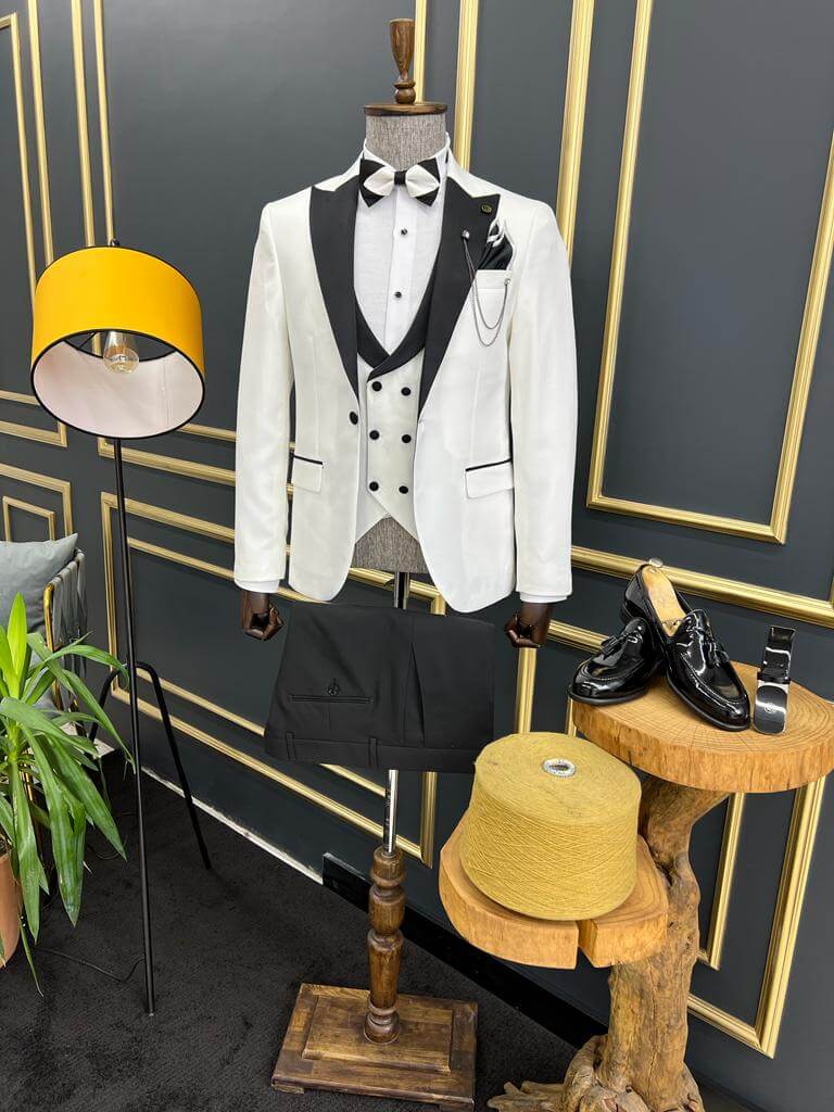 Slim-fit white tuxedo from HolloMen’s Spring Summer Collection, featuring a dovetail collar, double slits, single-button closure, and full formal set including jacket, vest, pants, shirt, and bow tie – ideal for weddings and upscale events.