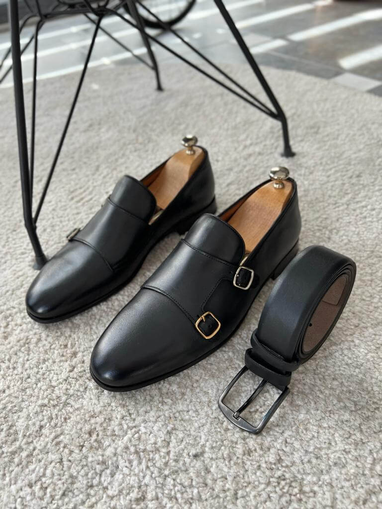 Elegant black leather double buckle monk strap shoes with a sleek finish and neolite sole, styled for modern formal wear and seasonal versatility.