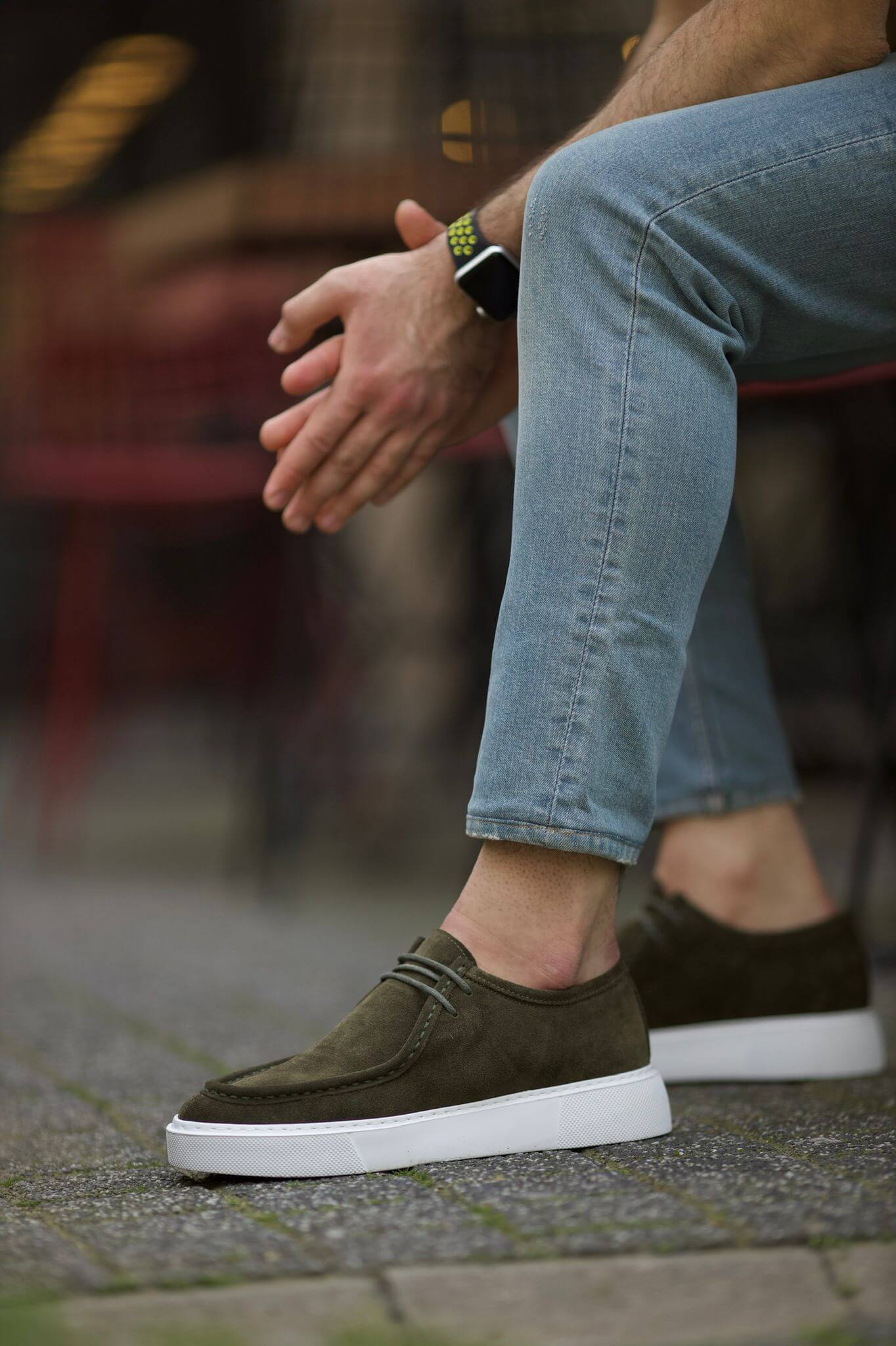 Lisbon Khaki Suede Casual Derby worn with light wash jeans, styled on a textured stone path.