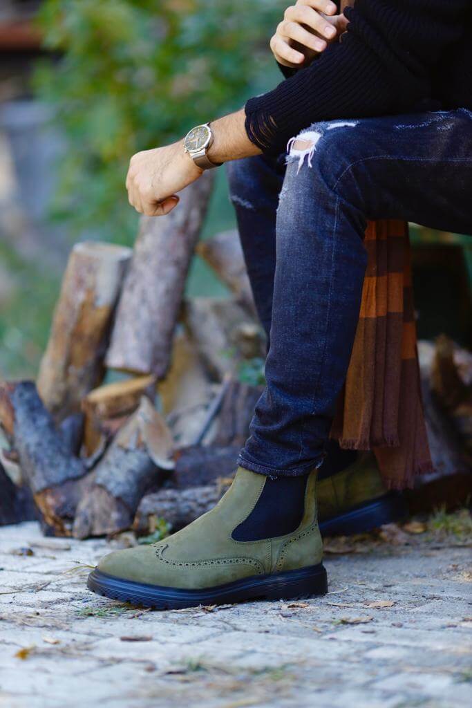 khaki nubuck Chelsea boots with elastic sides and black rugged soles, styled with black distressed jeans.