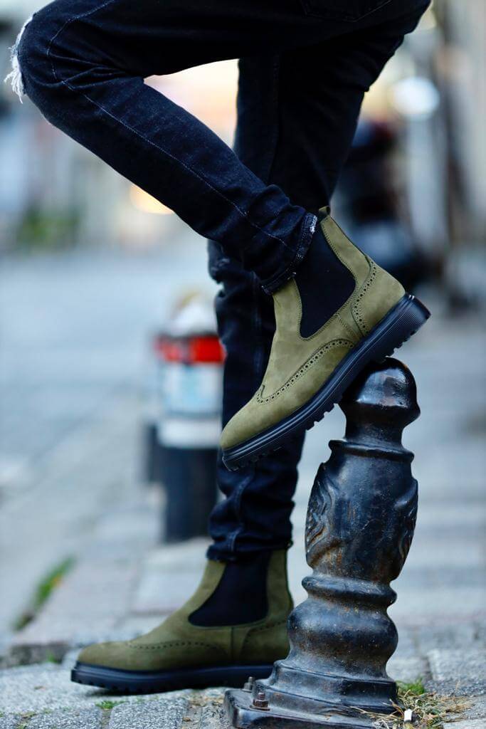 khaki nubuck Chelsea boots with elastic sides and black rugged soles, styled with black distressed jeans.