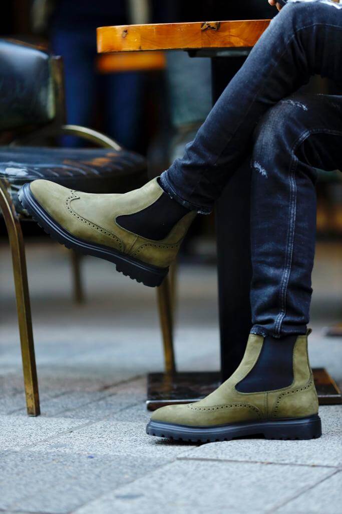khaki nubuck Chelsea boots with elastic sides and black rugged soles, styled with black distressed jeans.