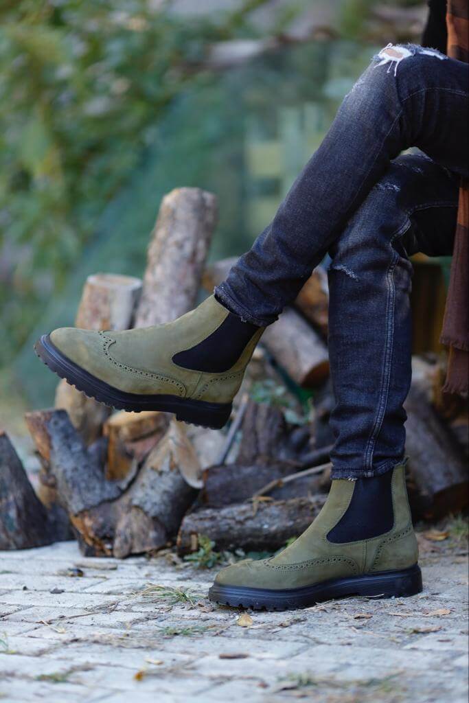 khaki nubuck Chelsea boots with elastic sides and black rugged soles, styled with black distressed jeans.