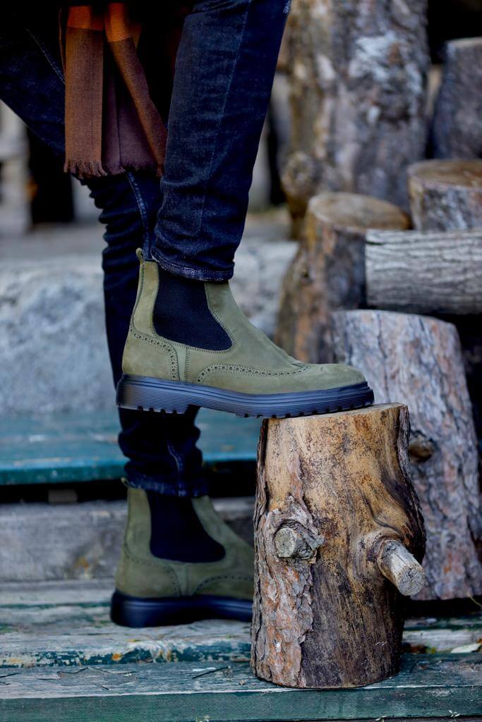 khaki nubuck Chelsea boots with elastic sides and black rugged soles, styled with black distressed jeans.