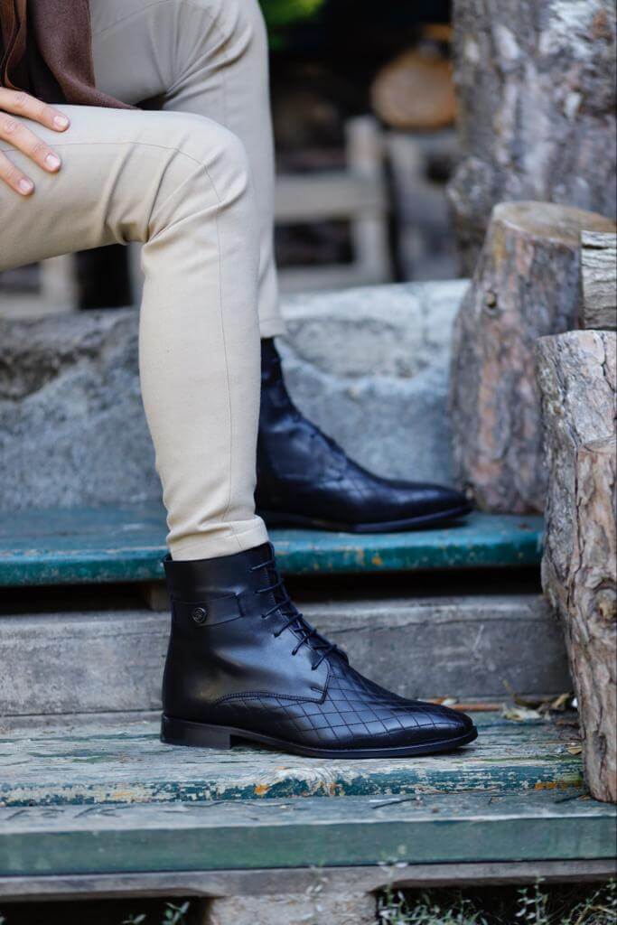 Wistman Black Classic Boots resting on a wooden stump, highlighting leather texture and ankle fit.