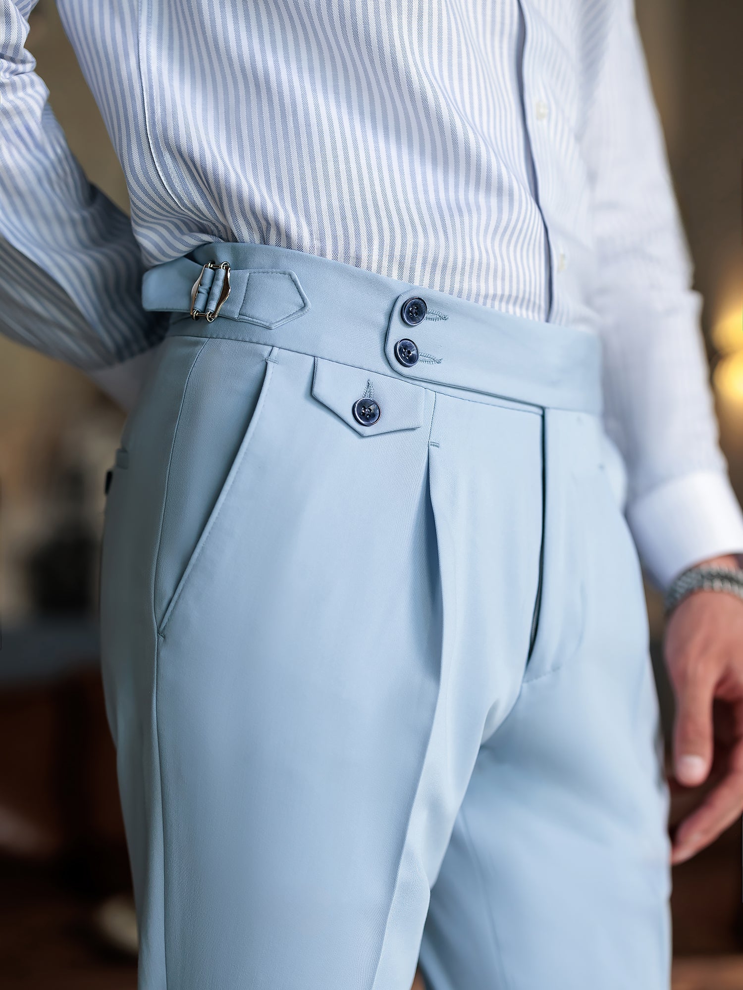 Men wearing a sky-blue double-breasted slim-fit suit with a white shirt and black tie, styled in a modern indoor setting.