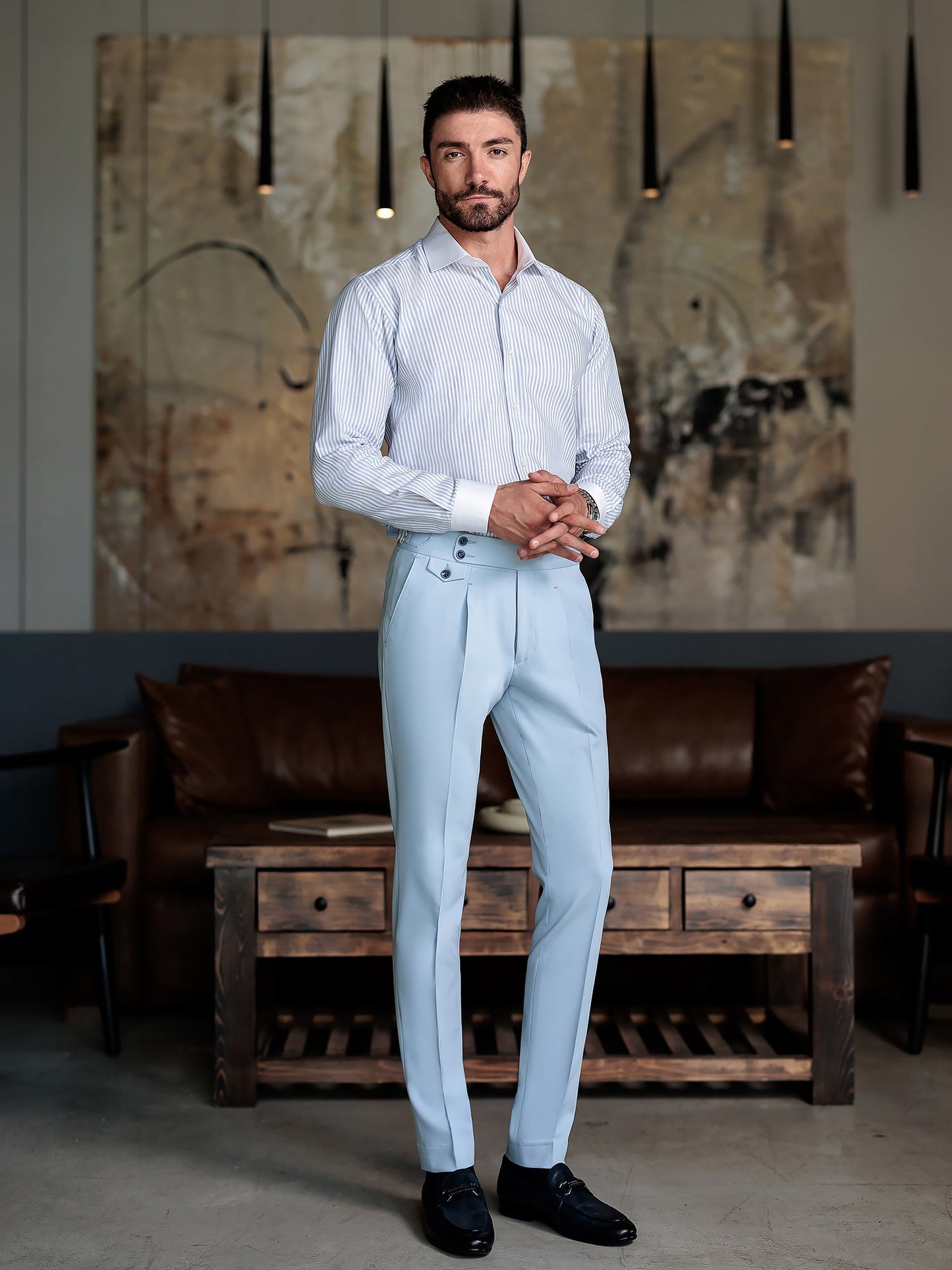 Men wearing a sky-blue double-breasted slim-fit suit with a white shirt and black tie, styled in a modern indoor setting.