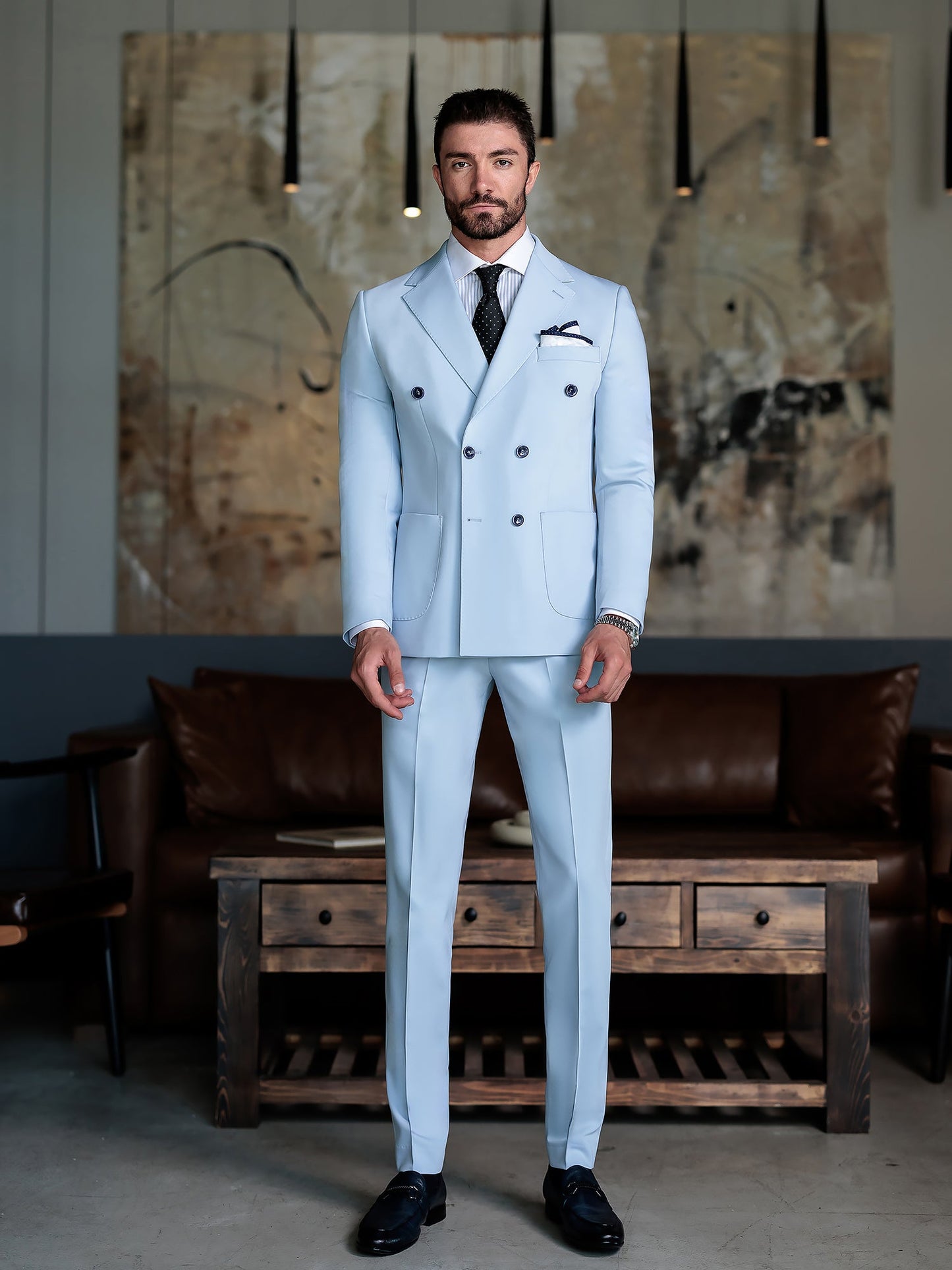 Men wearing a sky-blue double-breasted slim-fit suit with a white shirt and black tie, styled in a modern indoor setting.
