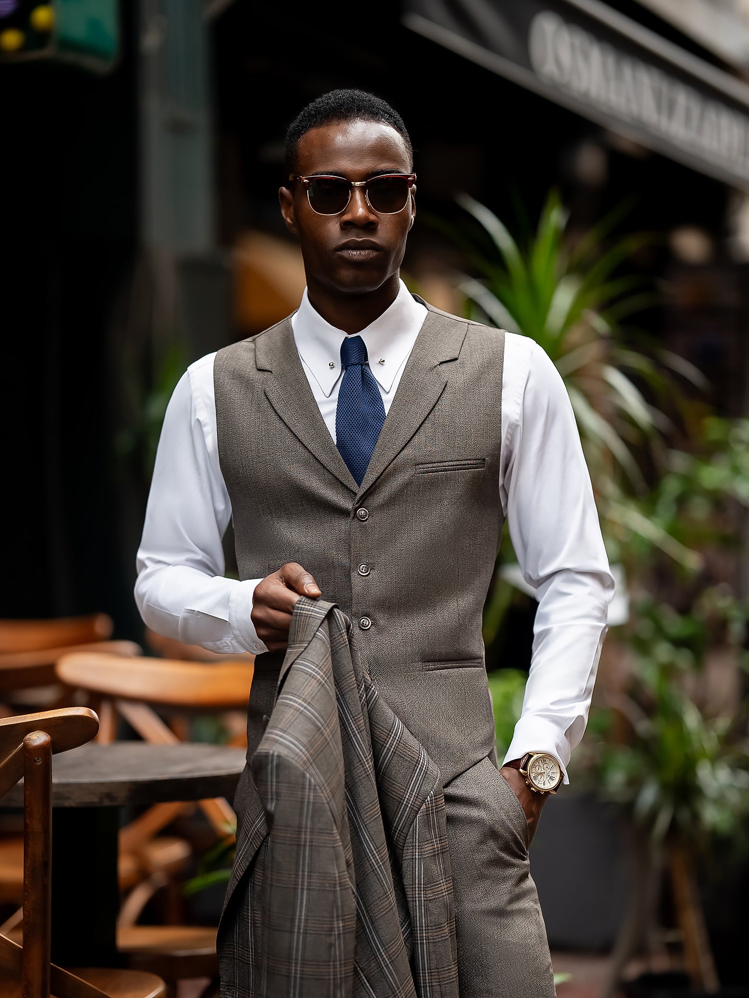 Men’s brown plaid slim-fit 3-piece suit with peak lapel blazer, matching vest and trousers, styled for formal and smart occasions with a modern tailored silhouette.