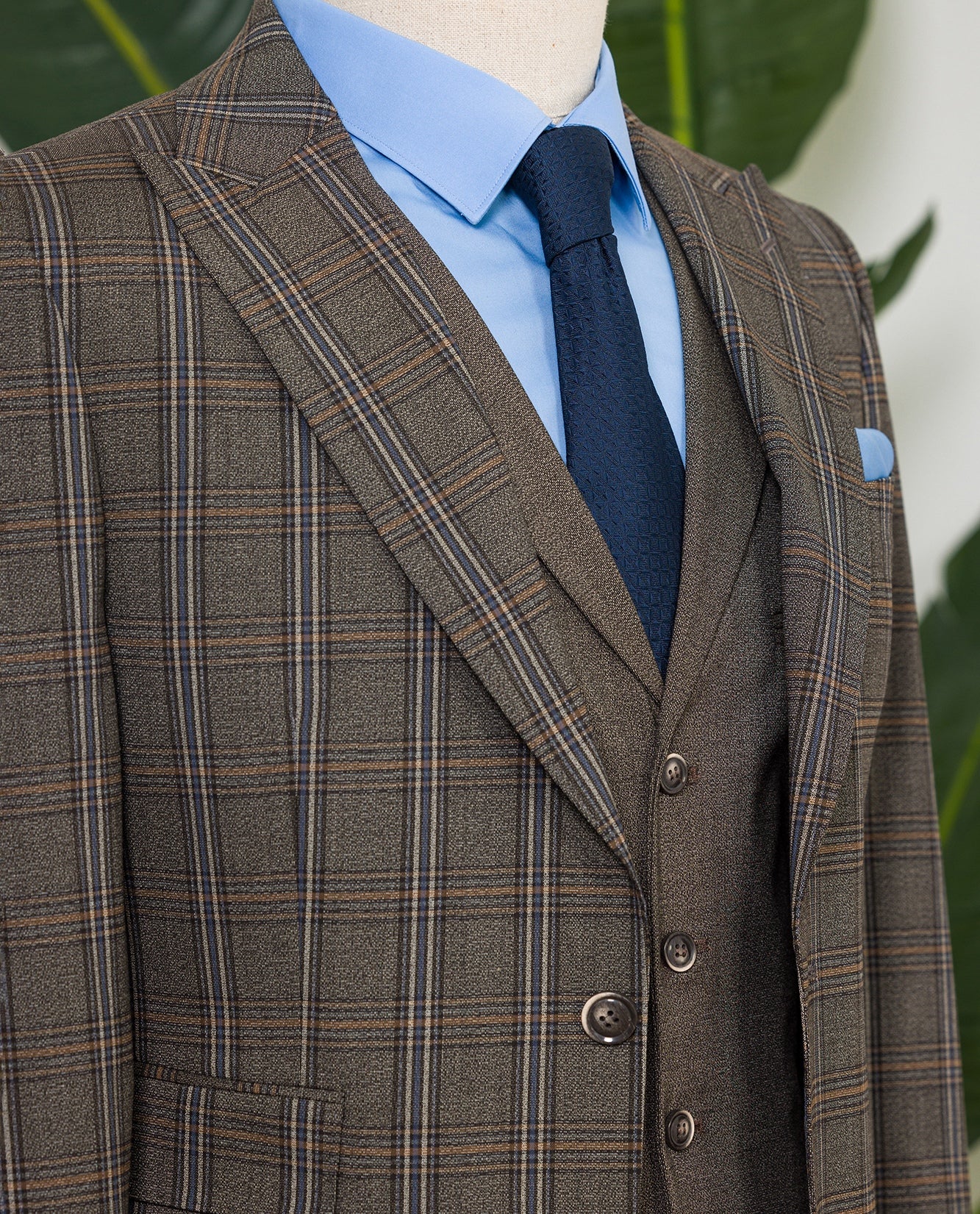 Men’s brown plaid slim-fit 3-piece suit with peak lapel blazer, matching vest and trousers, styled for formal and smart occasions with a modern tailored silhouette.