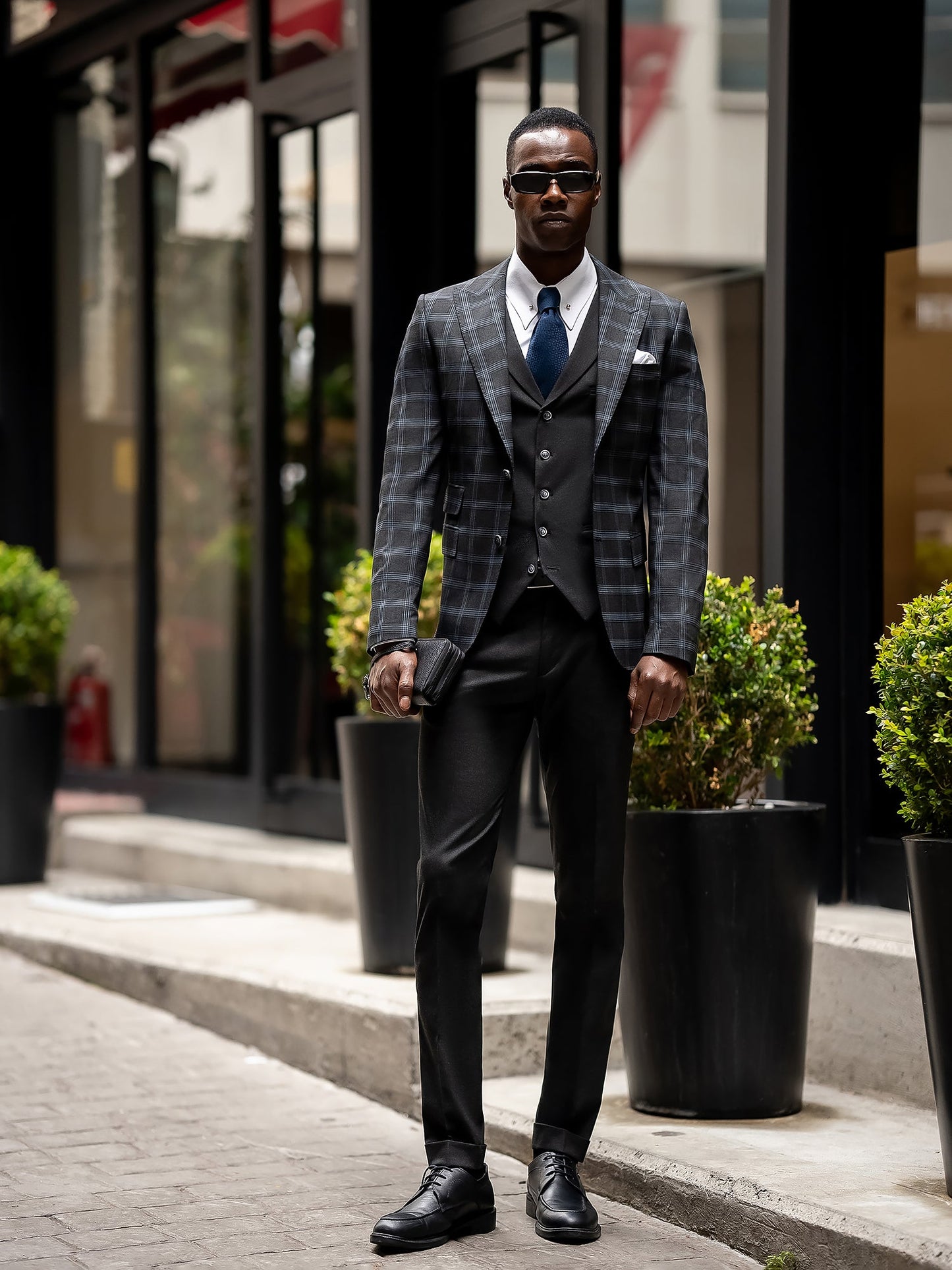 Men’s navy plaid slim-fit 3-piece suit with peak lapel blazer, matching vest and trousers, styled for business and formal occasions with a modern tailored fit.
