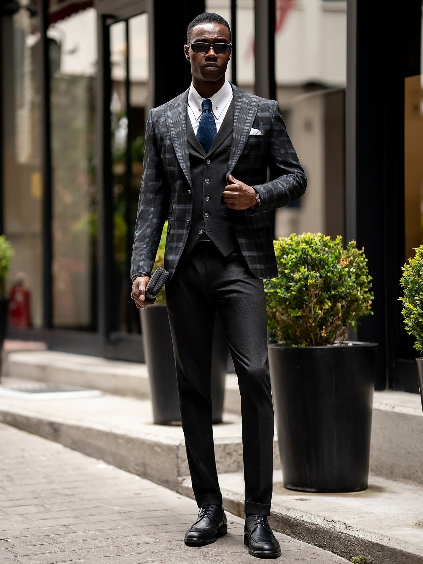 Men’s navy plaid slim-fit 3-piece suit with peak lapel blazer, matching vest and trousers, styled for business and formal occasions with a modern tailored fit.
