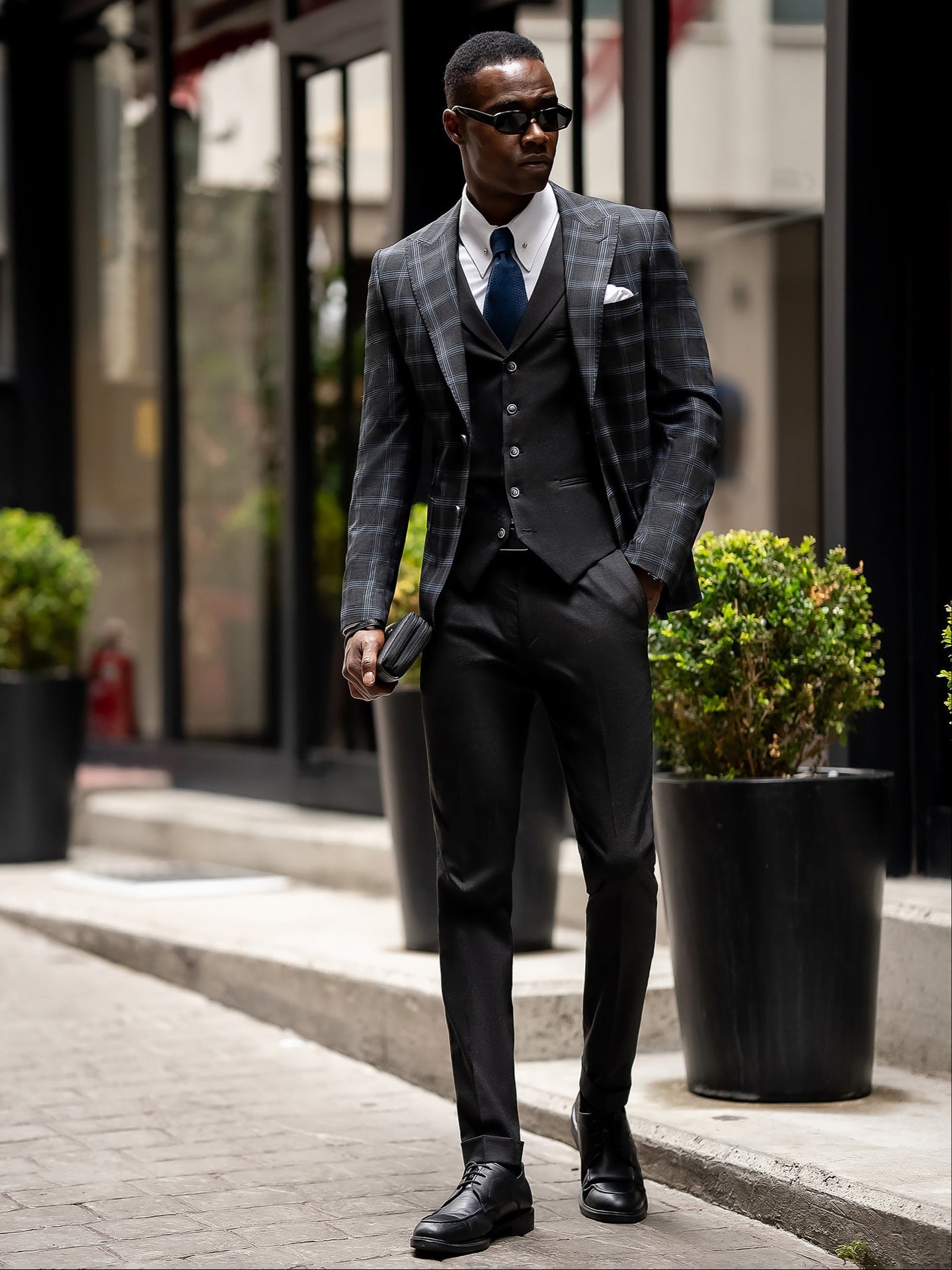 Men’s navy plaid slim-fit 3-piece suit with peak lapel blazer, matching vest and trousers, styled for business and formal occasions with a modern tailored fit.