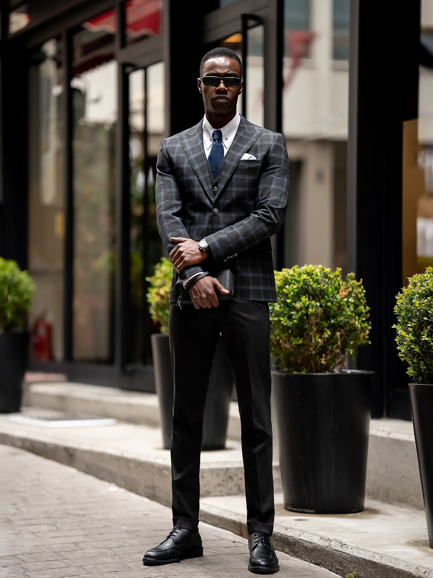 Men’s navy plaid slim-fit 3-piece suit with peak lapel blazer, matching vest and trousers, styled for business and formal occasions with a modern tailored fit.