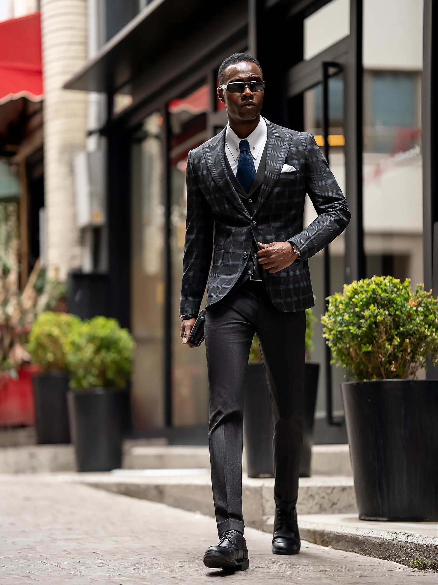 Men’s navy plaid slim-fit 3-piece suit with peak lapel blazer, matching vest and trousers, styled for business and formal occasions with a modern tailored fit.