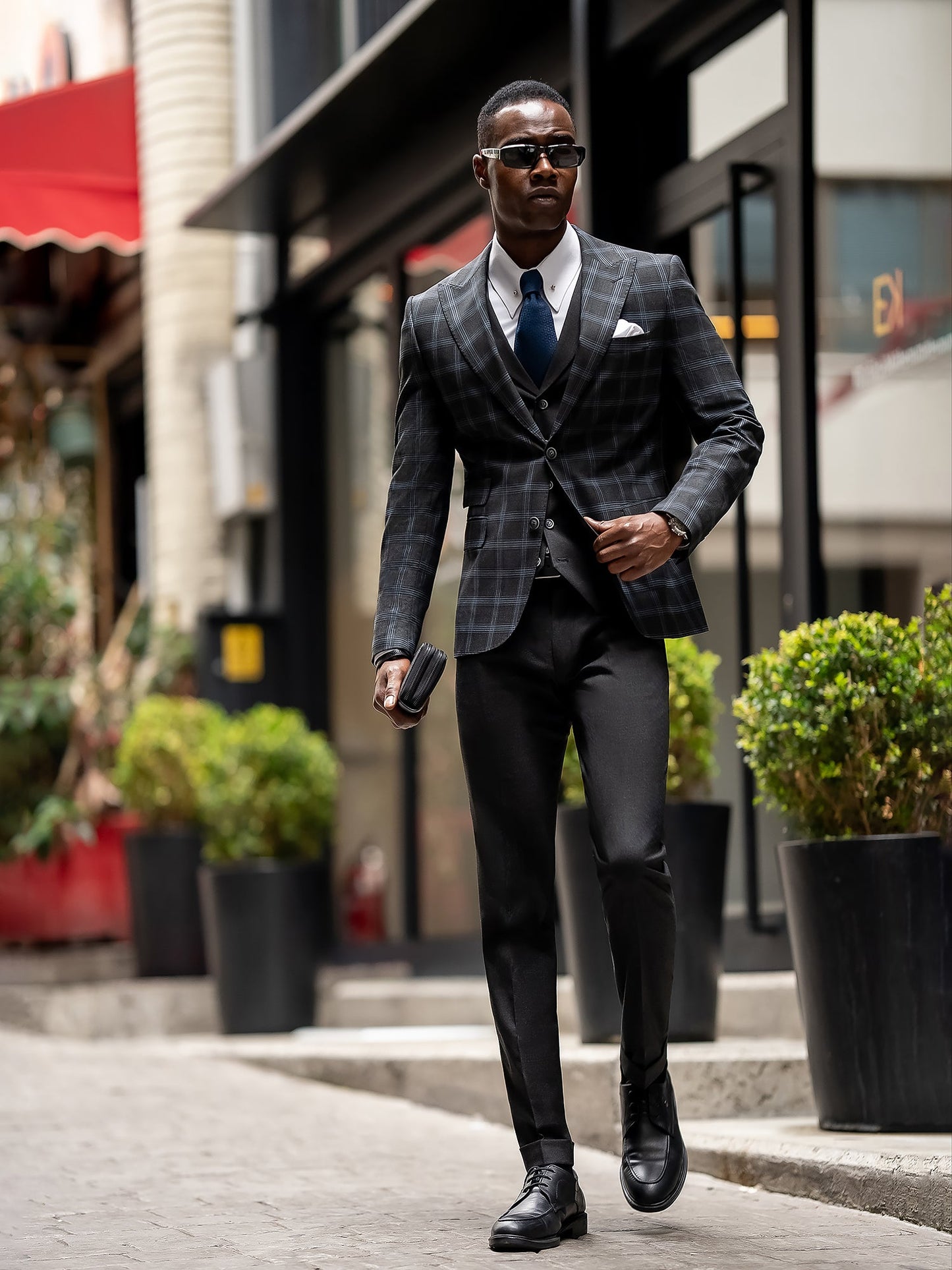 Men’s navy plaid slim-fit 3-piece suit with peak lapel blazer, matching vest and trousers, styled for business and formal occasions with a modern tailored fit.