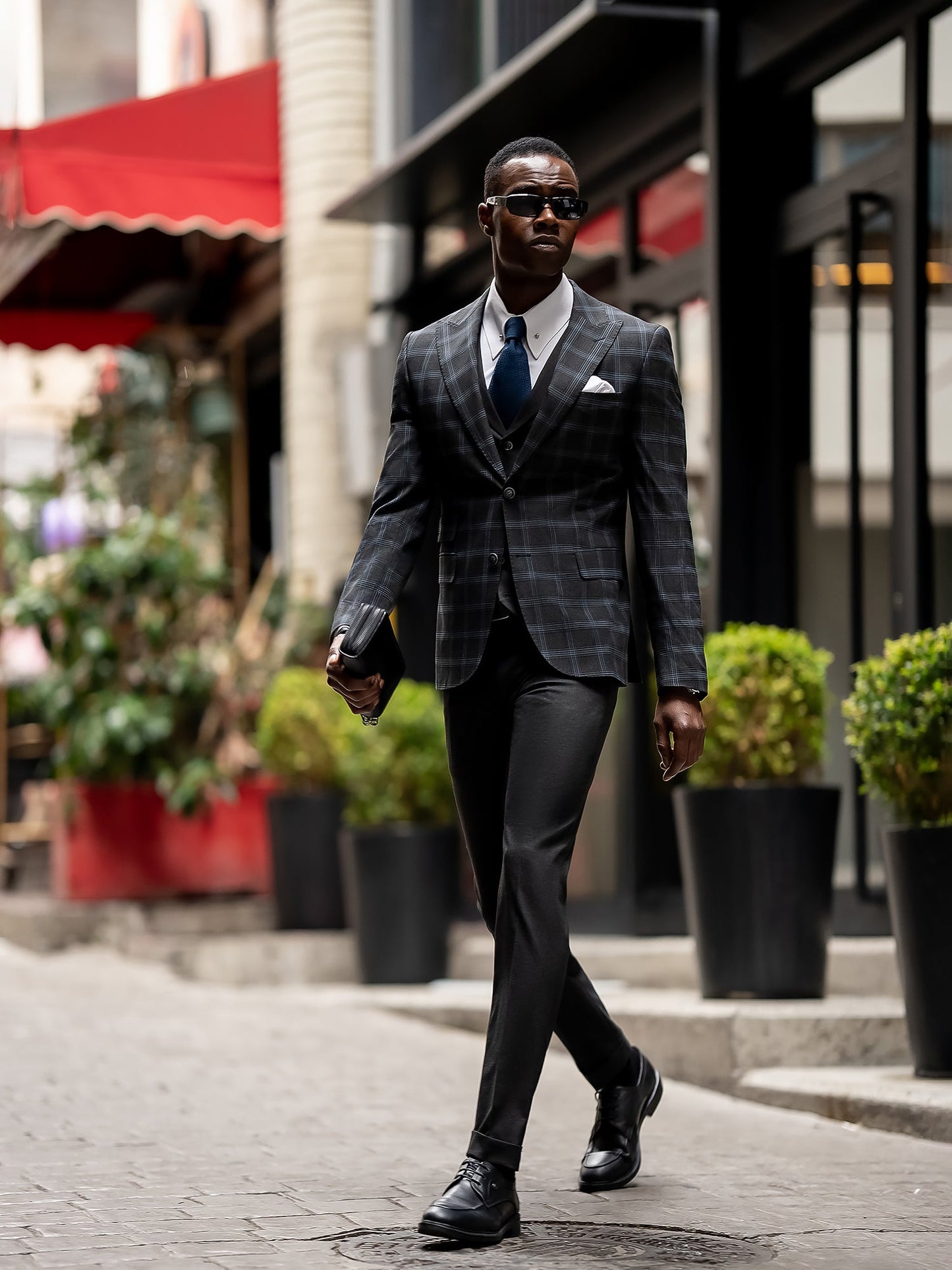 Men’s navy plaid slim-fit 3-piece suit with peak lapel blazer, matching vest and trousers, styled for business and formal occasions with a modern tailored fit.