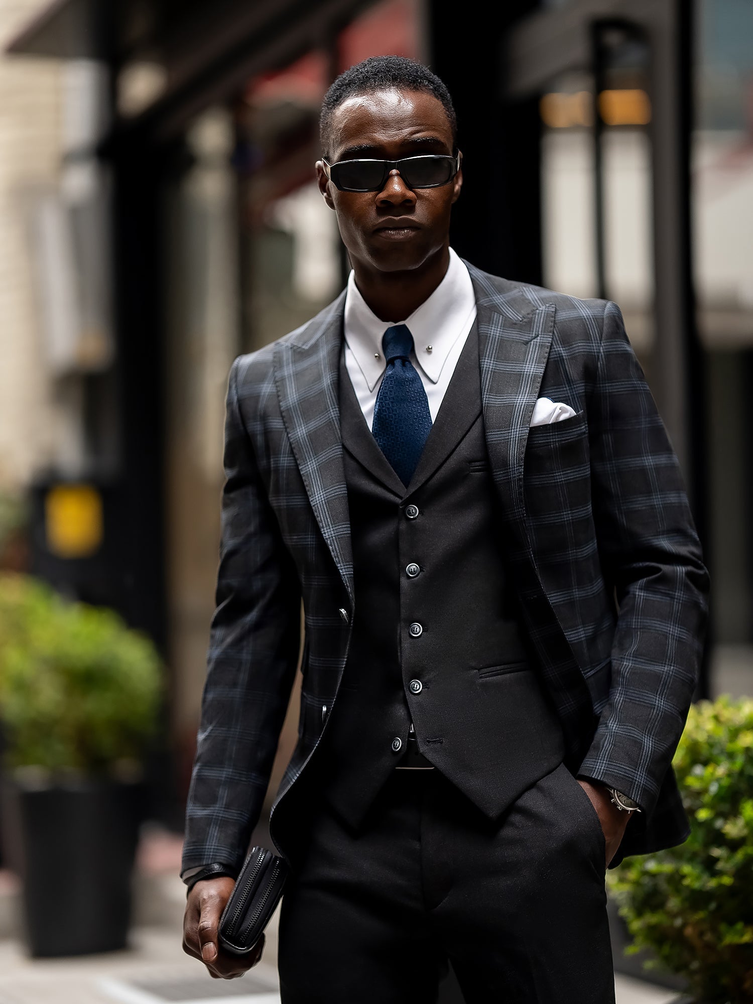 Men’s navy plaid slim-fit 3-piece suit with peak lapel blazer, matching vest and trousers, styled for business and formal occasions with a modern tailored fit.