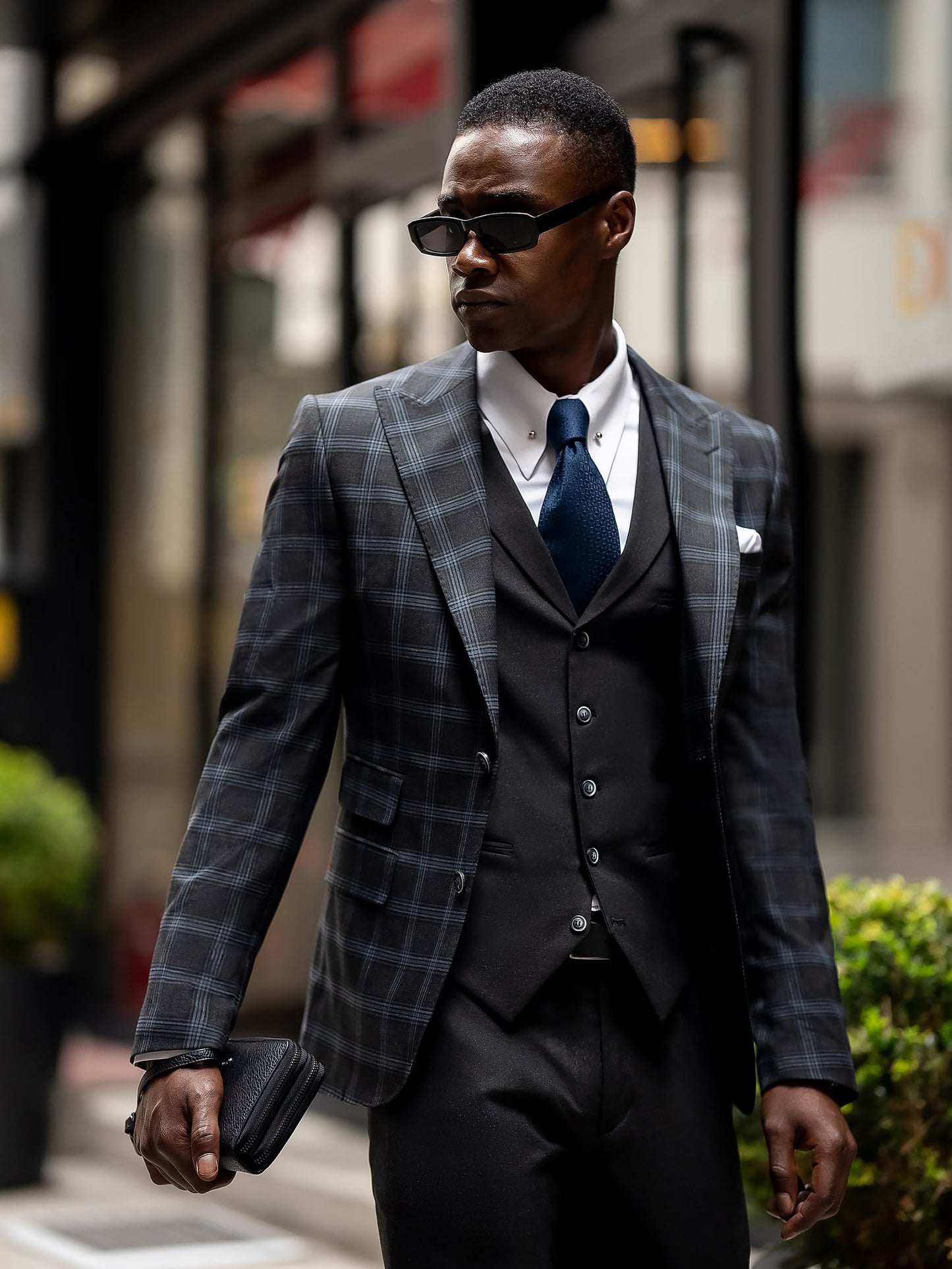 Men’s navy plaid slim-fit 3-piece suit with peak lapel blazer, matching vest and trousers, styled for business and formal occasions with a modern tailored fit.