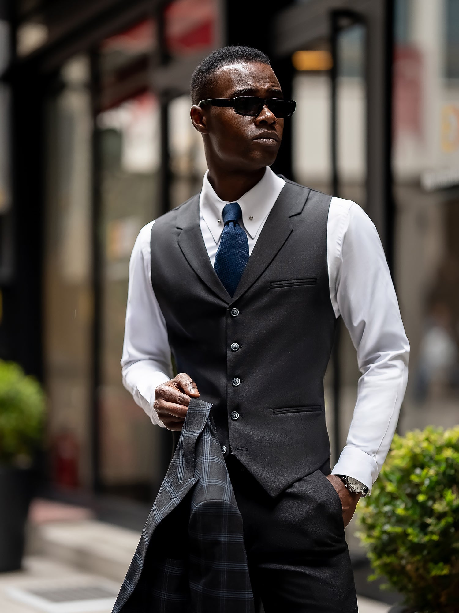Men’s navy plaid slim-fit 3-piece suit with peak lapel blazer, matching vest and trousers, styled for business and formal occasions with a modern tailored fit.