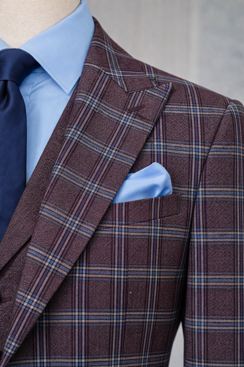Men’s bordeaux plaid slim-fit 3-piece suit with peak lapel blazer, matching vest and trousers, styled for formal and smart occasions with a modern tailored fit.