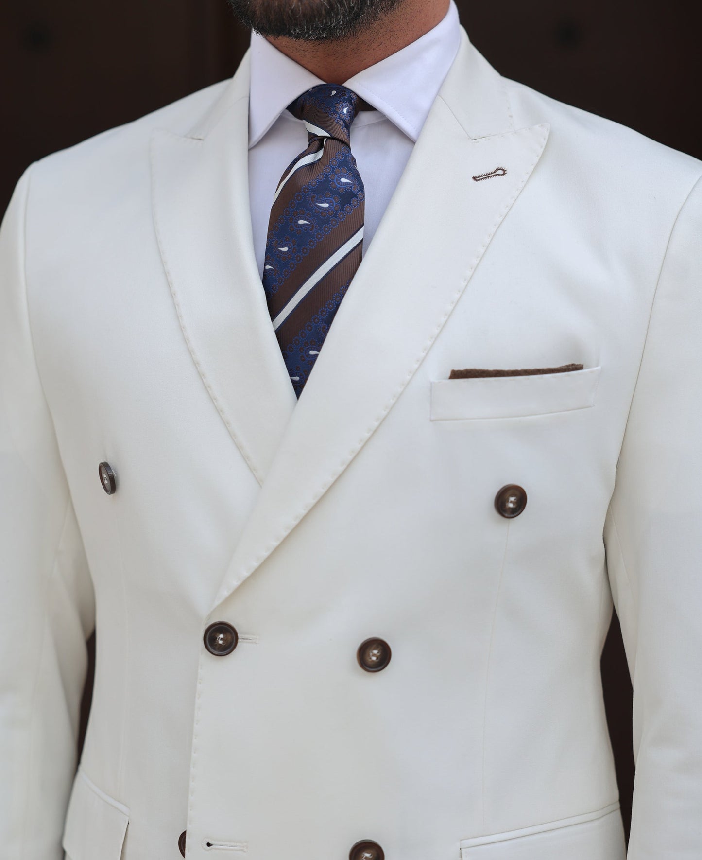 Men’s white double-breasted slim-fit suit with tailored trousers, styled with a dress shirt and tie for a clean, modern formal look.