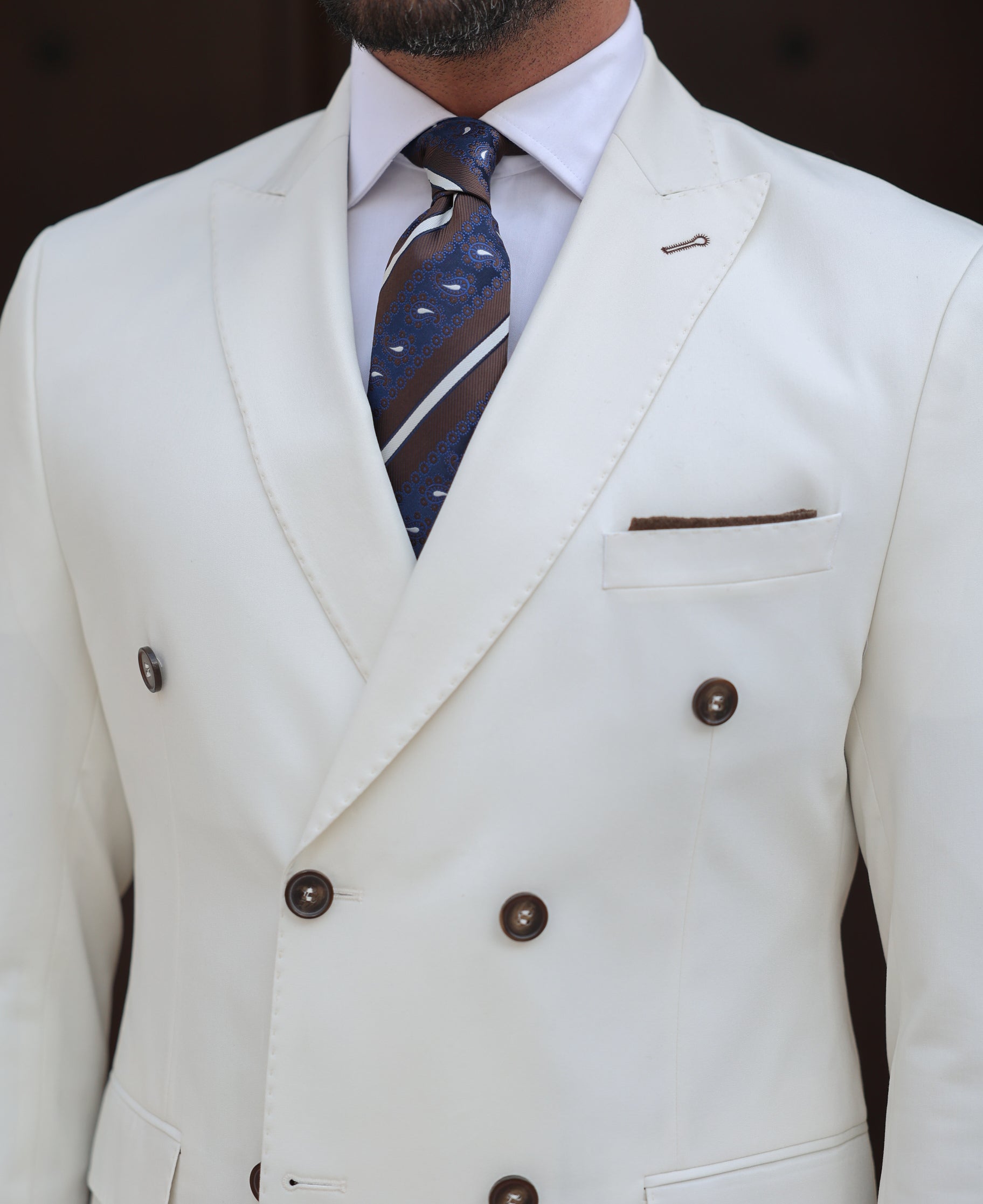 Men’s white double-breasted slim-fit suit with tailored trousers, styled with a dress shirt and tie for a clean, modern formal look.