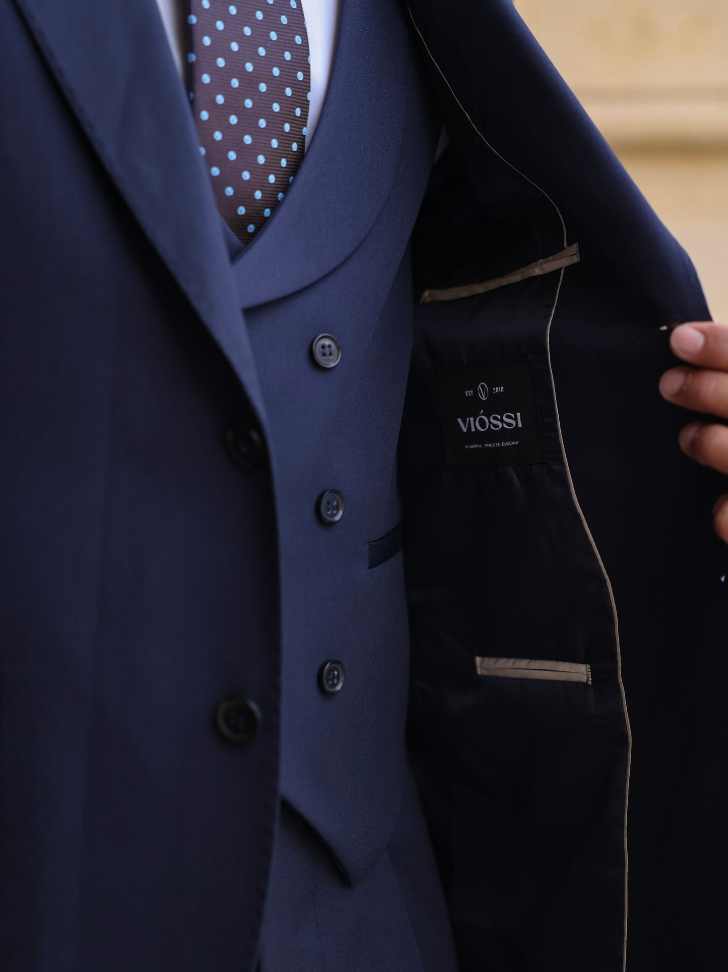 Men’s navy modern-fit 3-piece suit with blazer, waistcoat, and trousers, styled with a white shirt and patterned tie for a clean, elegant look.