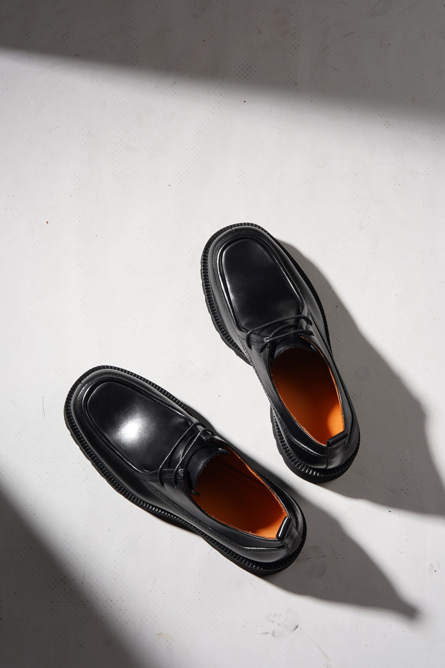 Pair of Black Apron-Toe Chunky Derby Shoes with chunky sole displayed stylishly