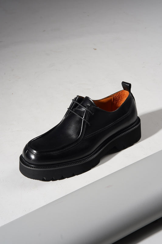 Pair of Black Apron-Toe Chunky Derby Shoes with chunky sole displayed stylishly