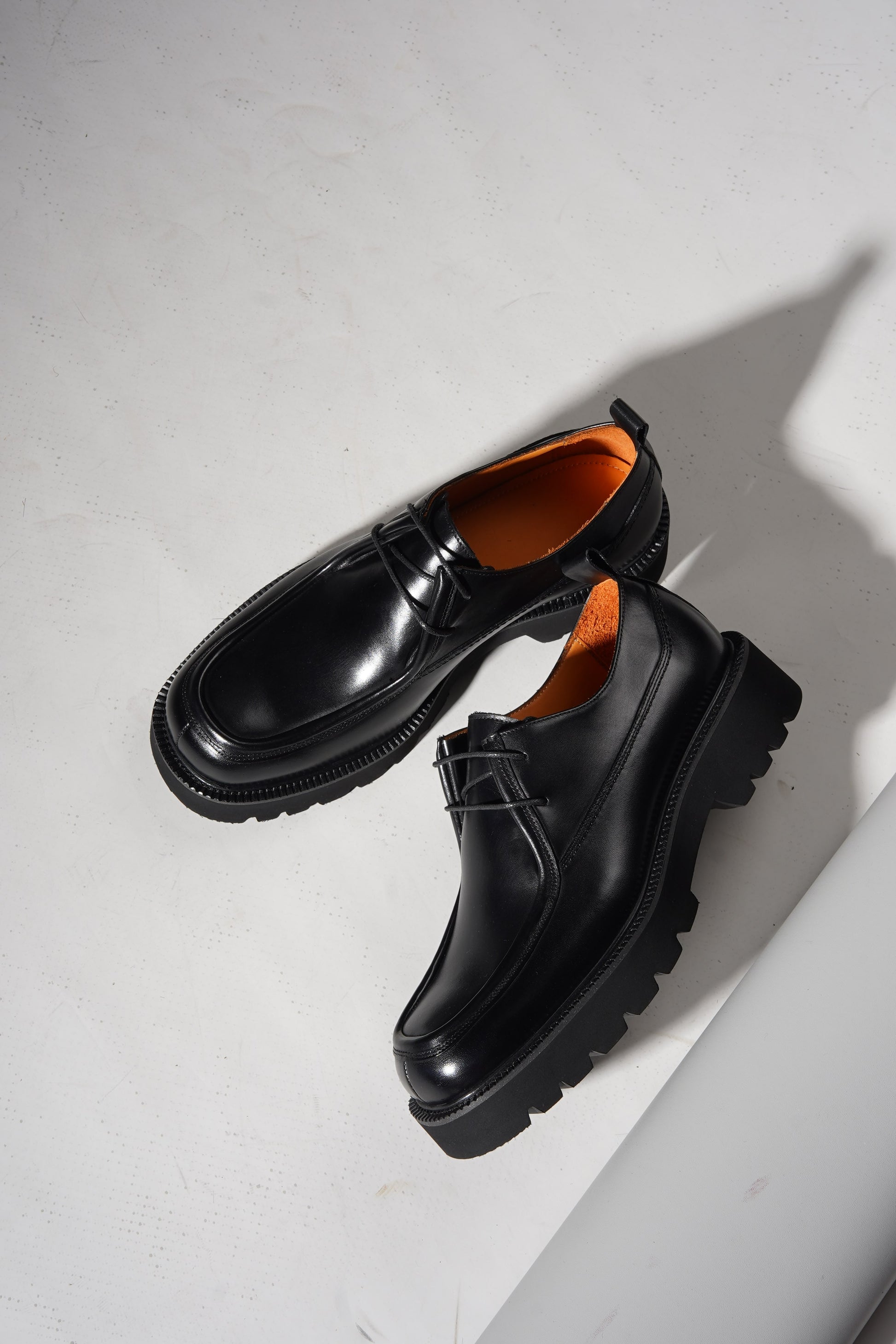 Pair of Black Apron-Toe Chunky Derby Shoes with chunky sole displayed stylishly