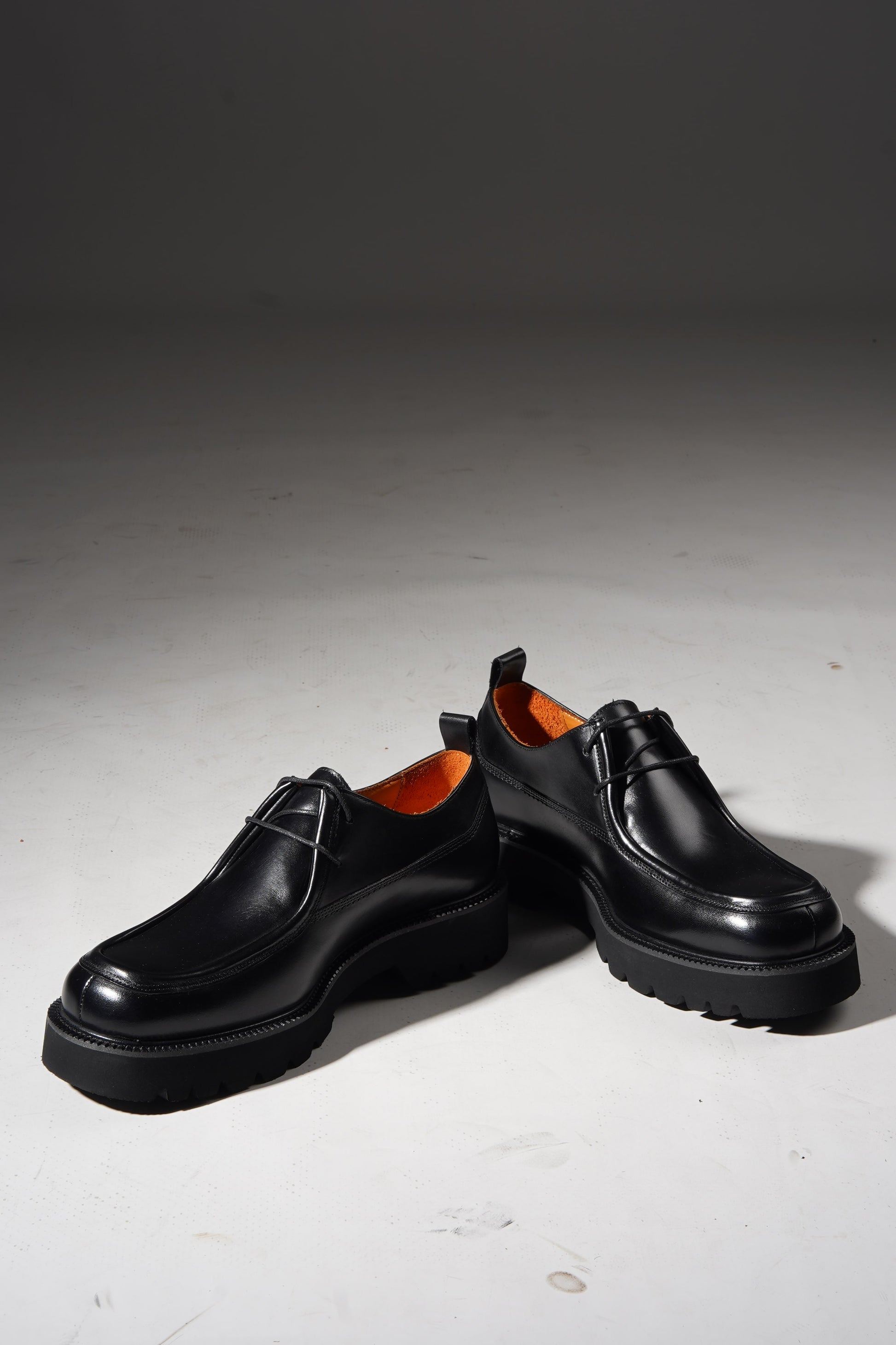 Pair of Black Apron-Toe Chunky Derby Shoes with chunky sole displayed stylishly