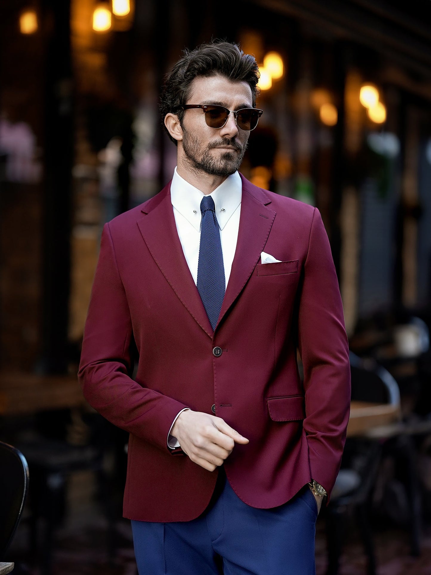 Men’s bordeaux slim-fit blazer with peak lapels, single-breasted design, double vents, and tailored silhouette, styled for formal and smart-casual occasions.