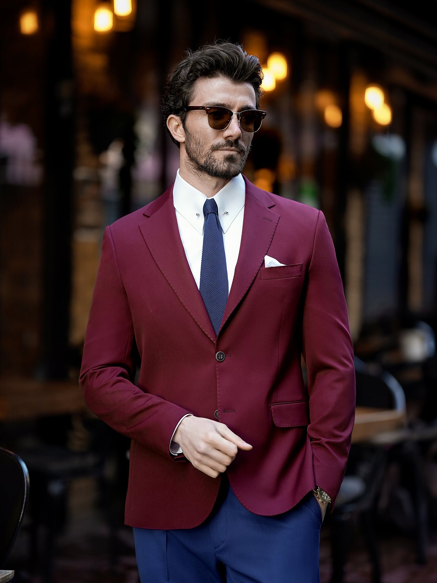 Men’s bordeaux slim-fit blazer with peak lapels, single-breasted design, double vents, and tailored silhouette, styled for formal and smart-casual occasions.