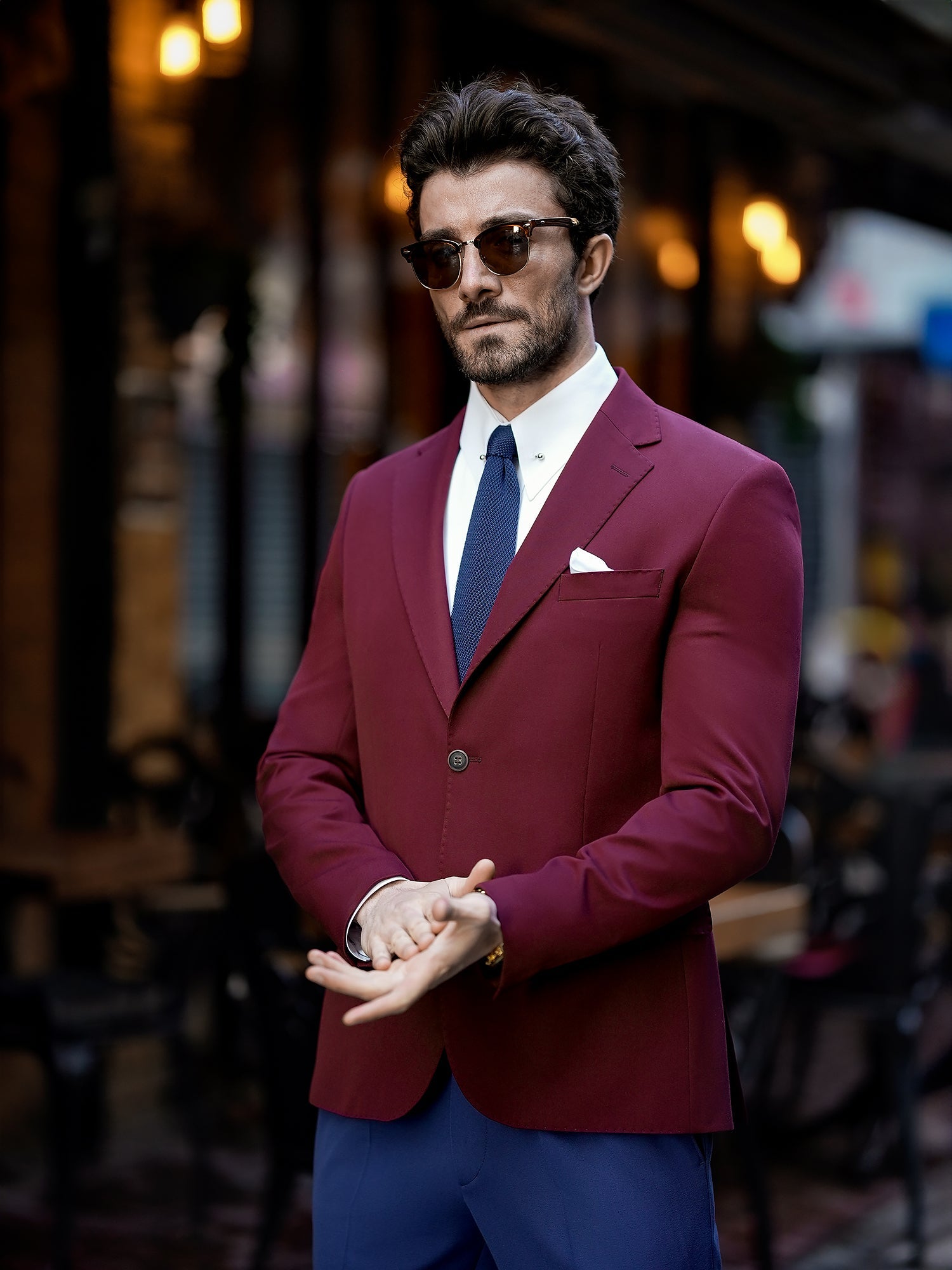 Men’s bordeaux slim-fit blazer with peak lapels, single-breasted design, double vents, and tailored silhouette, styled for formal and smart-casual occasions.