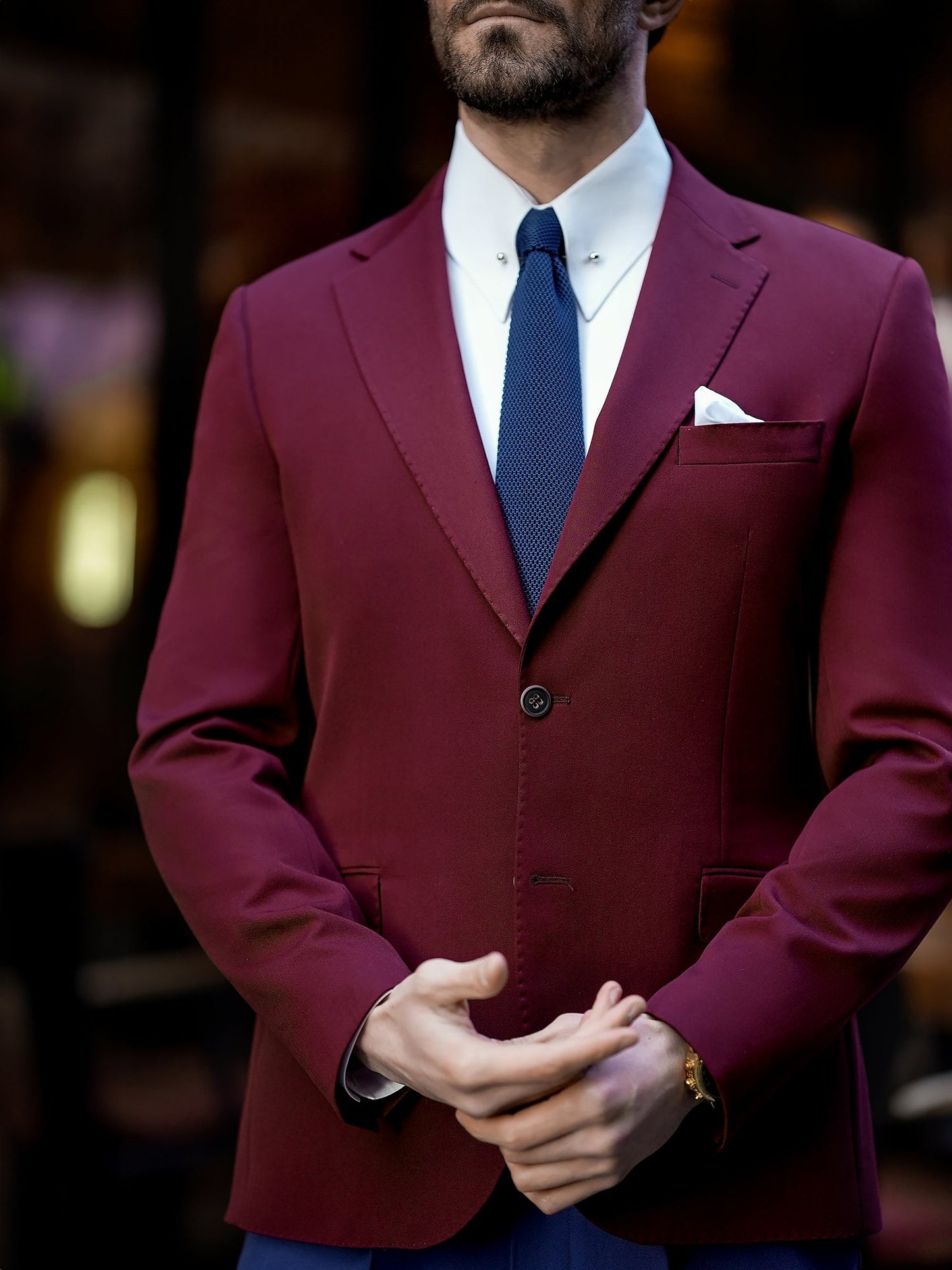 Men’s bordeaux slim-fit blazer with peak lapels, single-breasted design, double vents, and tailored silhouette, styled for formal and smart-casual occasions.
