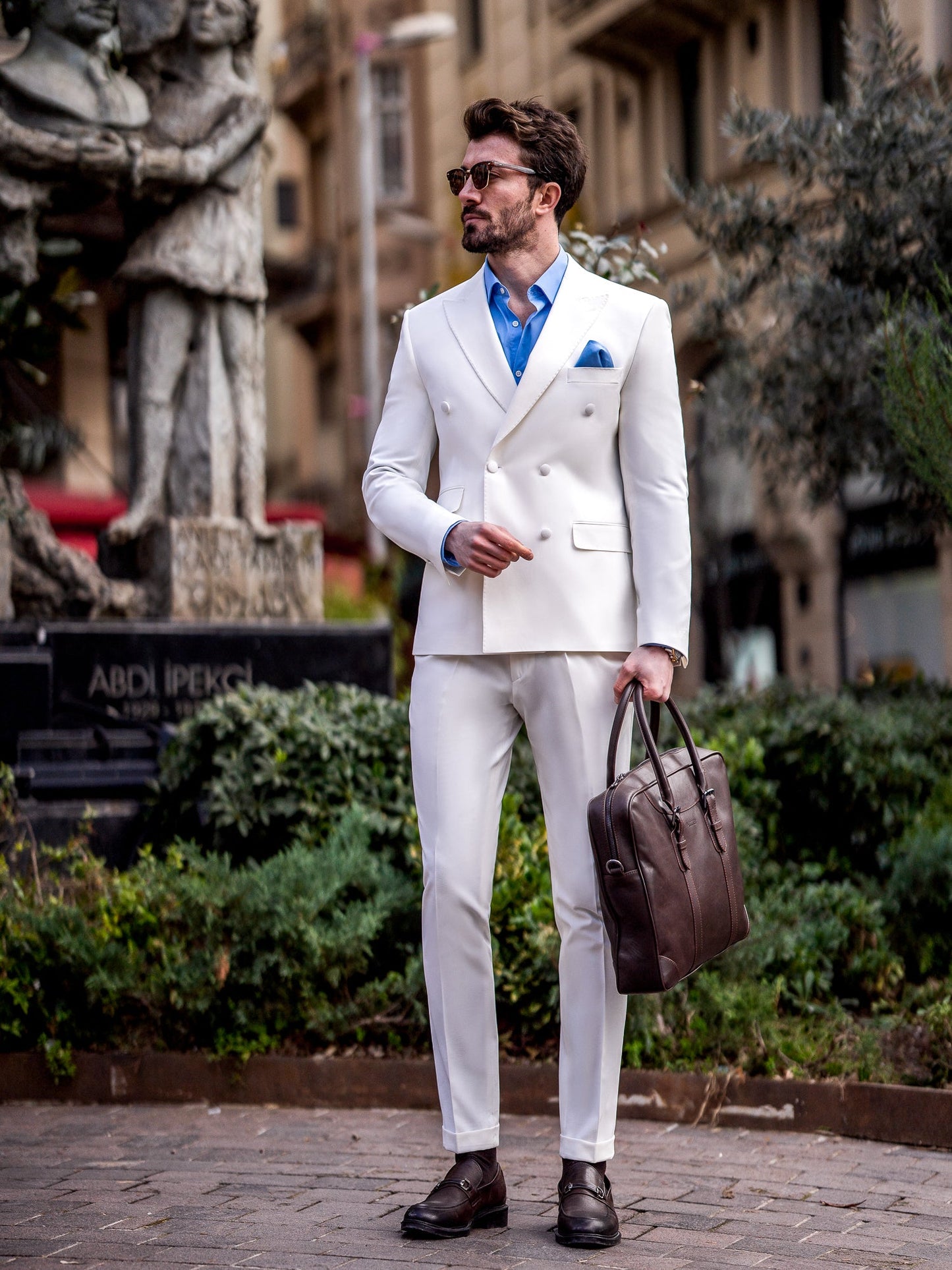 Men’s white slim-fit double-breasted suit with peak lapel blazer and tailored trousers, featuring a six-button design, double vents, and a modern structured silhouette for formal occasions.