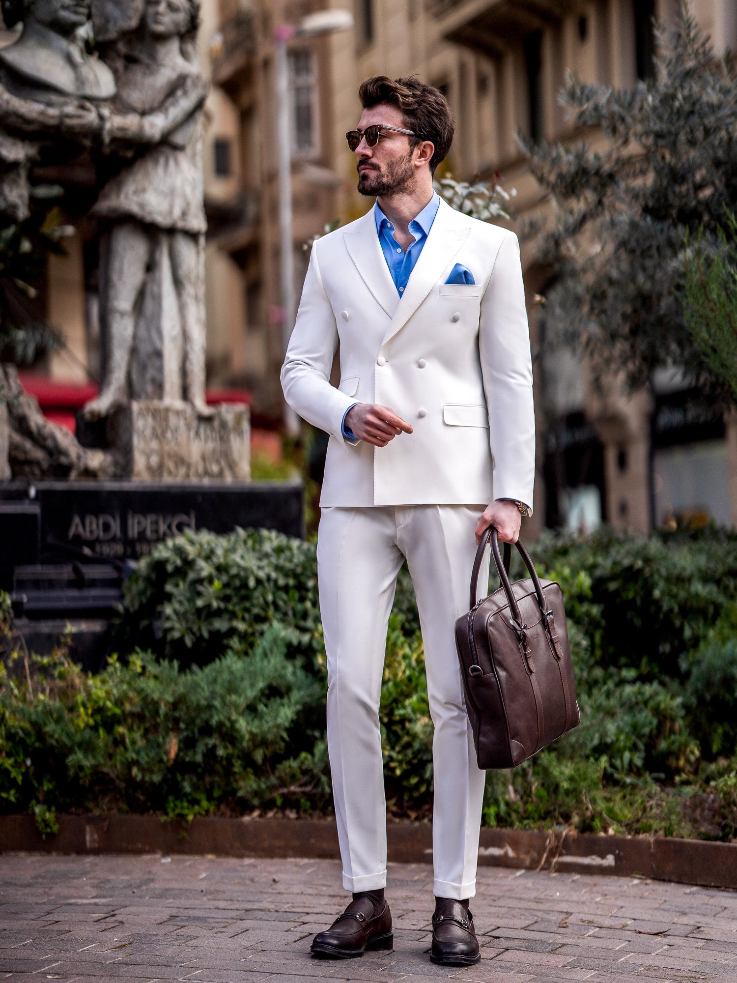 Men’s white slim-fit double-breasted suit with peak lapel blazer and tailored trousers, featuring a six-button design, double vents, and a modern structured silhouette for formal occasions.