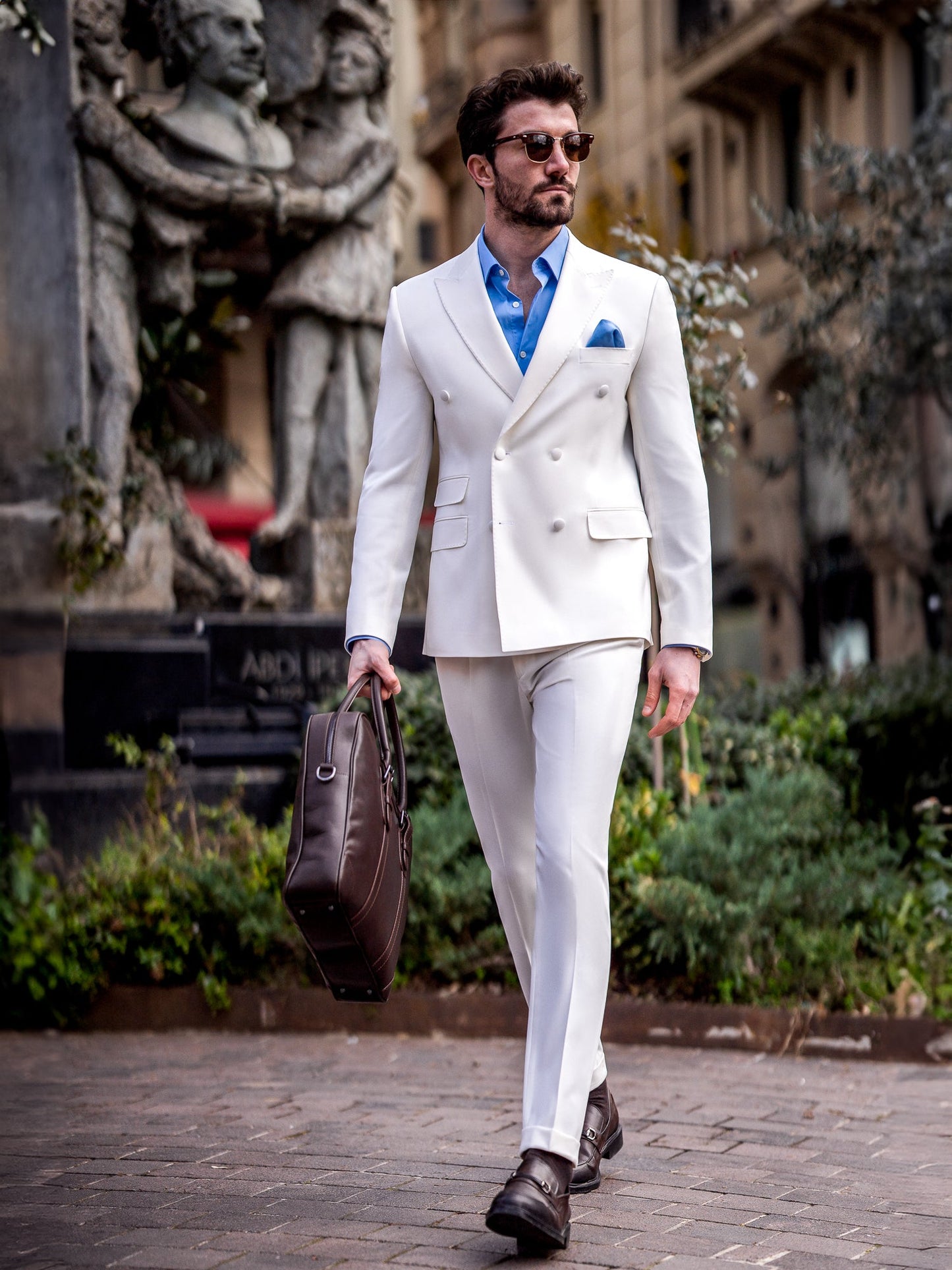Men’s white slim-fit double-breasted suit with peak lapel blazer and tailored trousers, featuring a six-button design, double vents, and a modern structured silhouette for formal occasions.