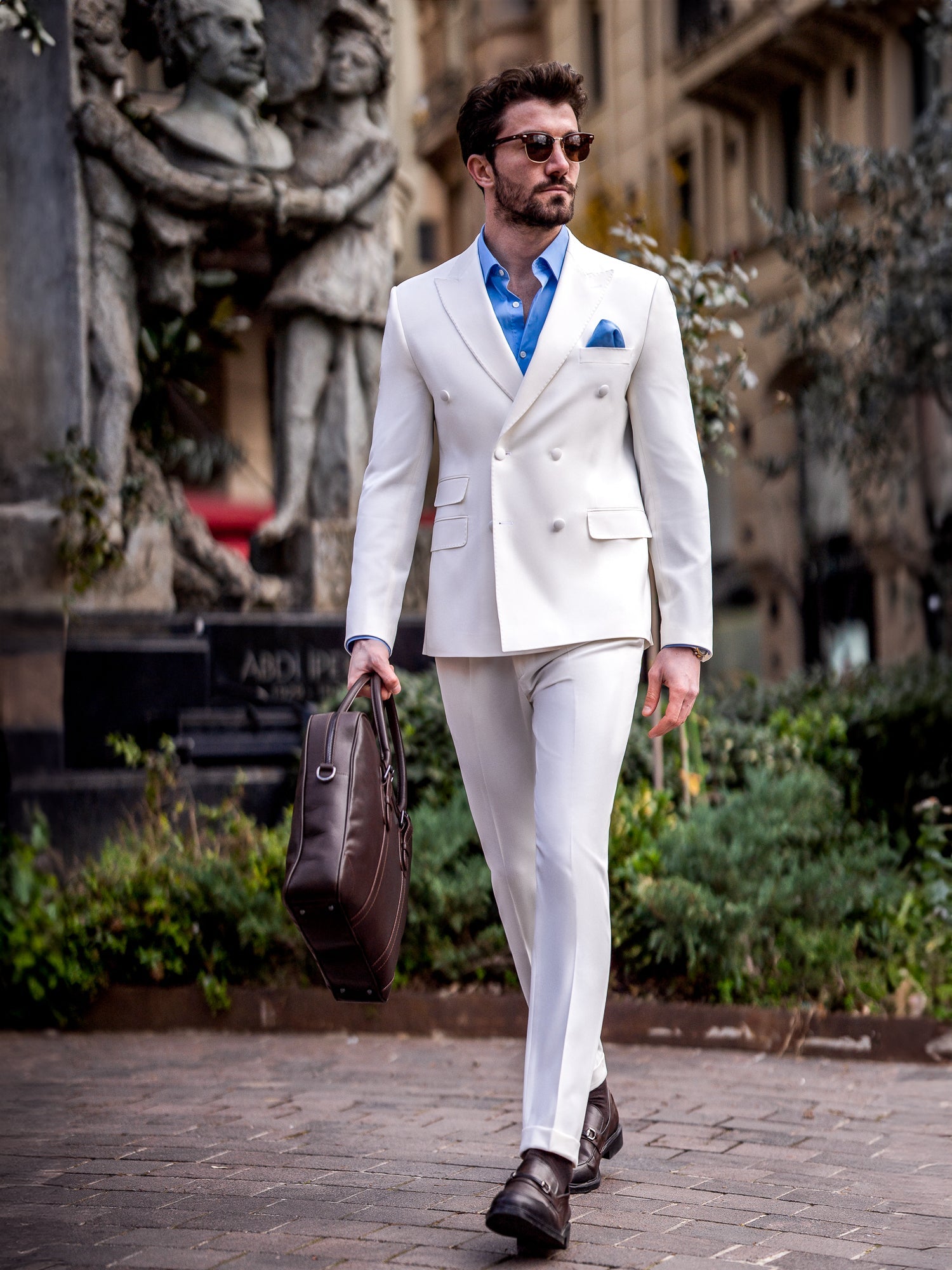 Men’s white slim-fit double-breasted suit with peak lapel blazer and tailored trousers, featuring a six-button design, double vents, and a modern structured silhouette for formal occasions.