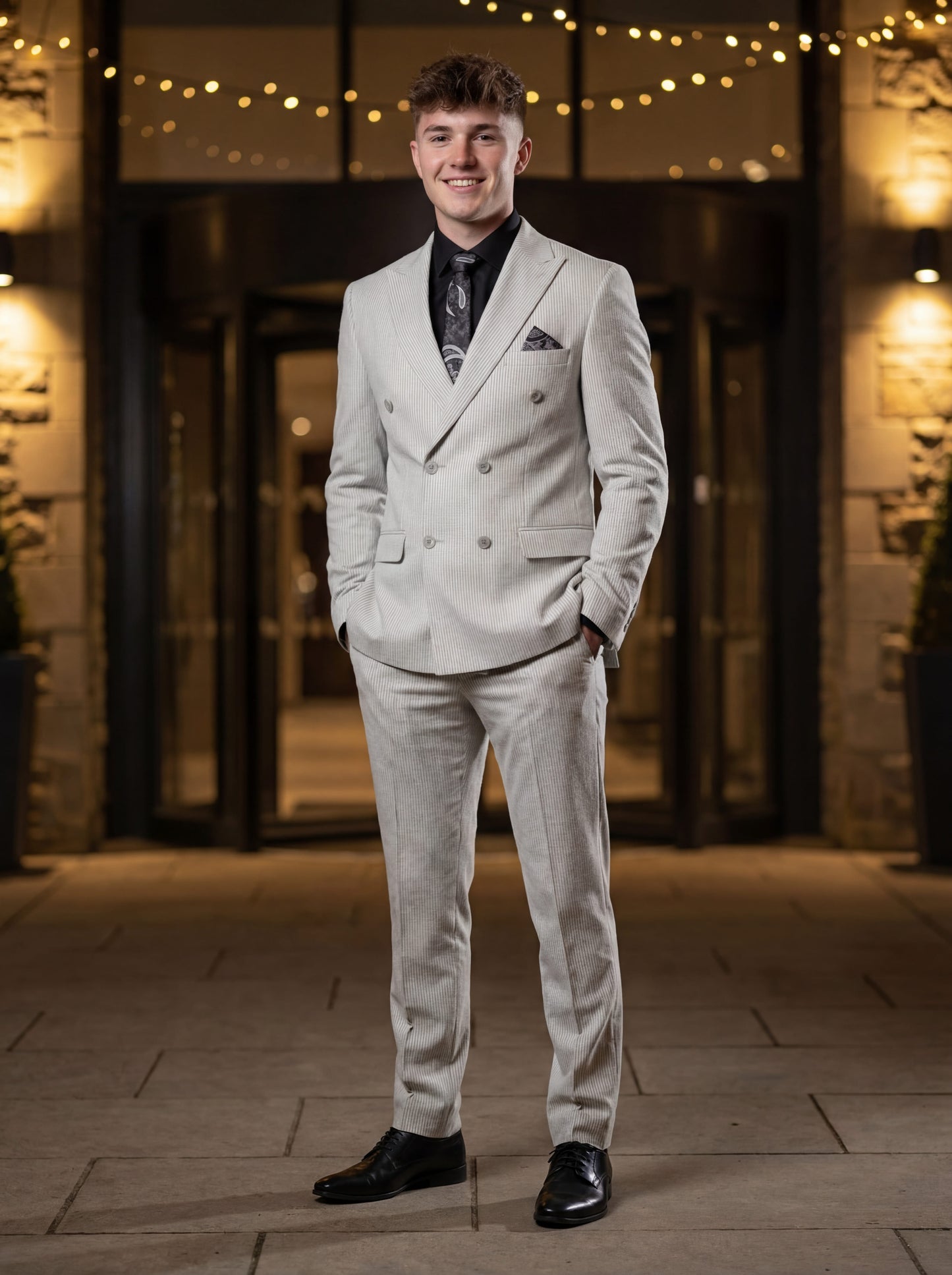 Gray double-breasted pinstripe prom suit worn by young male model at formal event