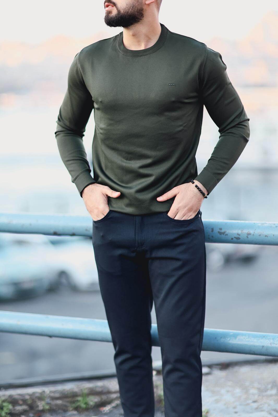Men’s green long-sleeve cotton-blend polo sweater worn outdoors, showcasing fitted design and ribbed collar