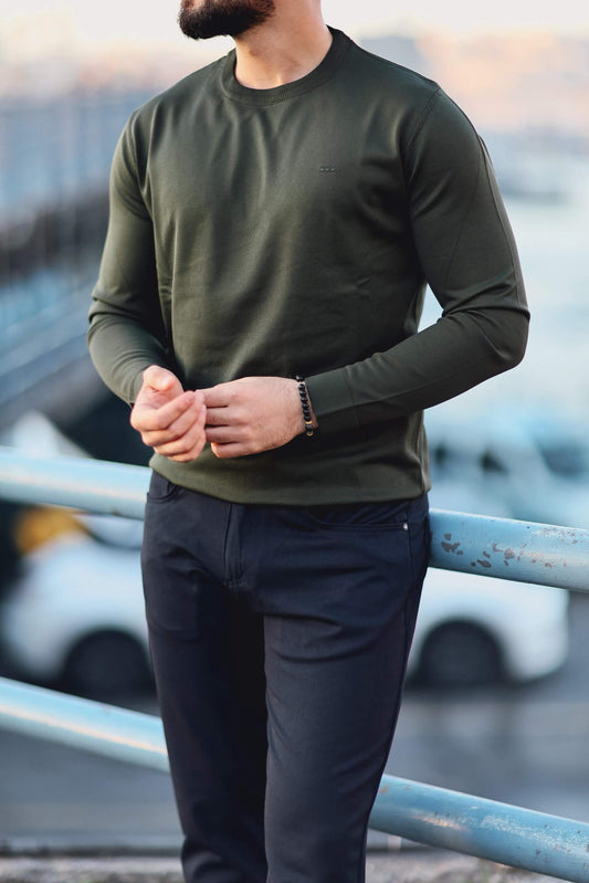 Men’s green long-sleeve cotton-blend polo sweater worn outdoors, showcasing fitted design and ribbed collar