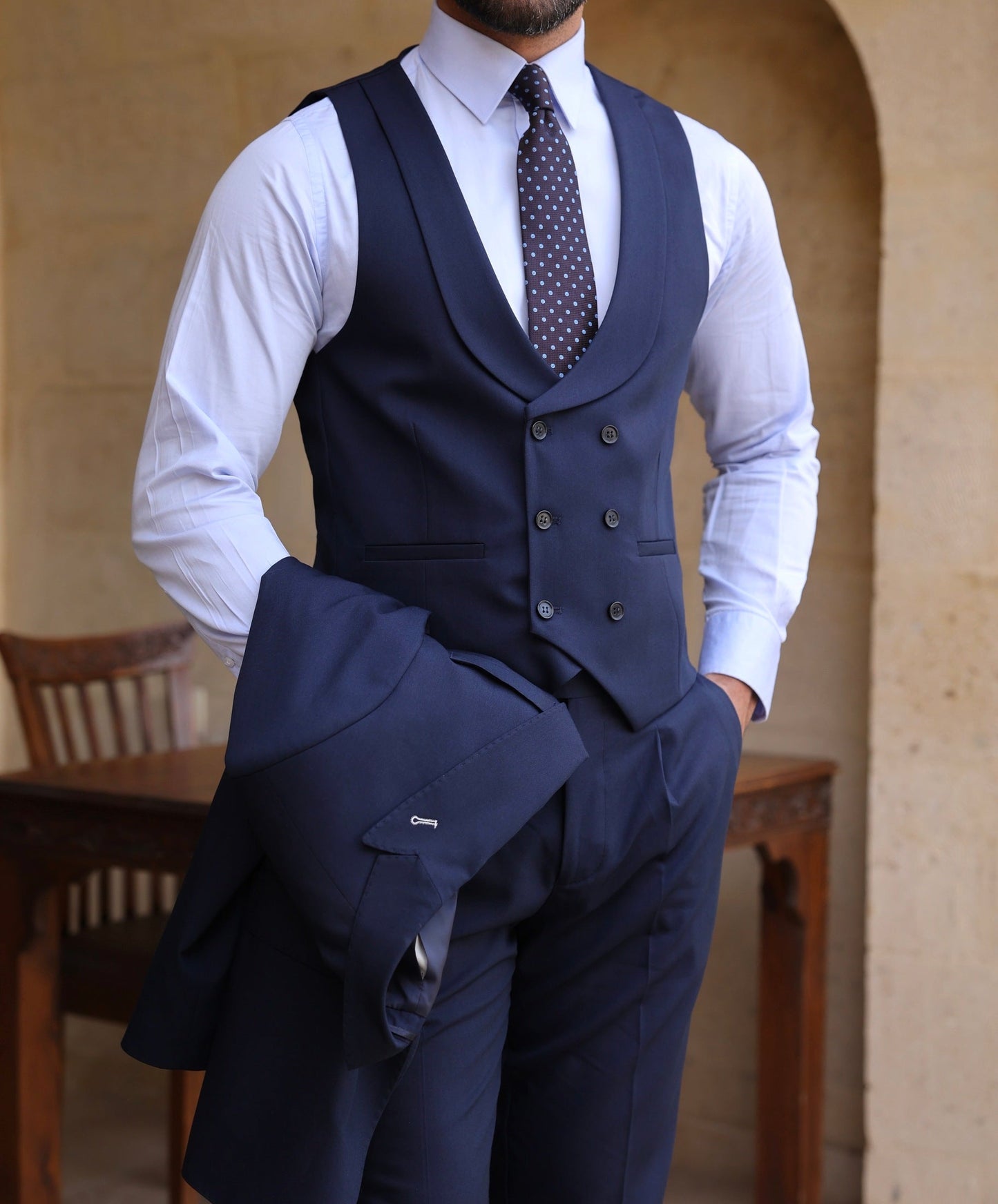 Men’s navy modern-fit 3-piece suit with blazer, waistcoat, and trousers, styled with a white shirt and patterned tie for a clean, elegant look.