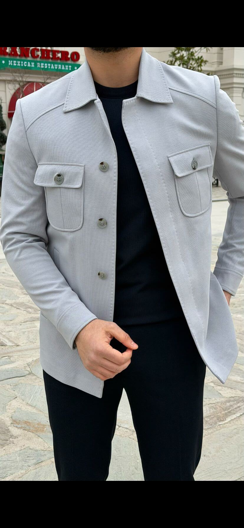 Men’s ice blue shirt jacket with flap pockets styled with black outfit and white sneakers in a modern smart casual look