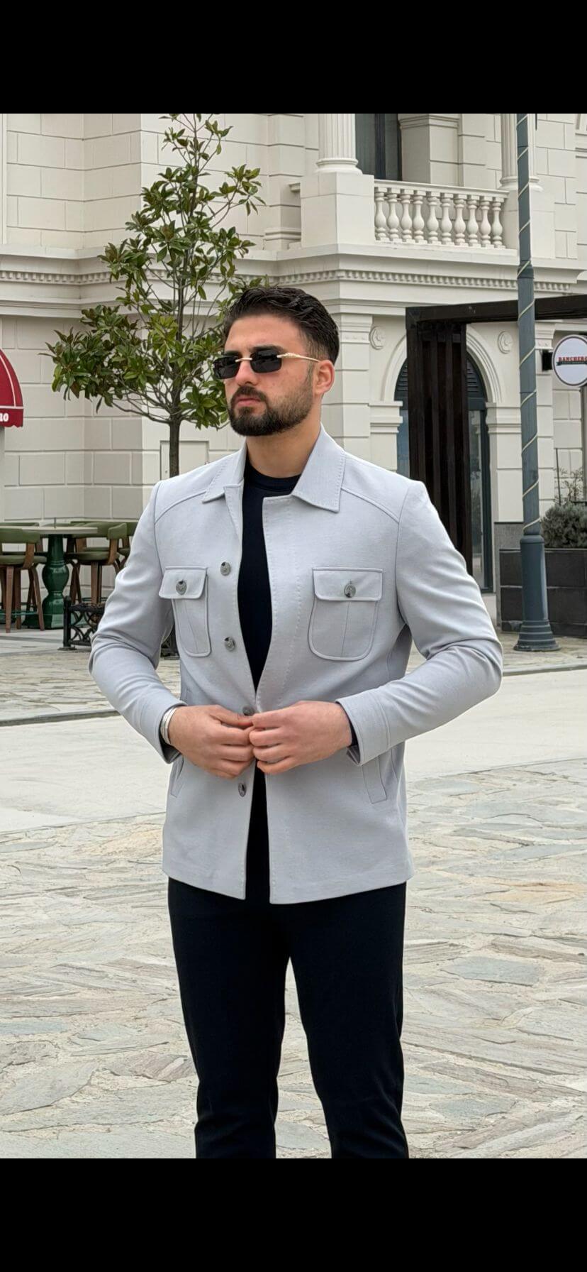Men’s ice blue shirt jacket with flap pockets styled with black outfit and white sneakers in a modern smart casual look
