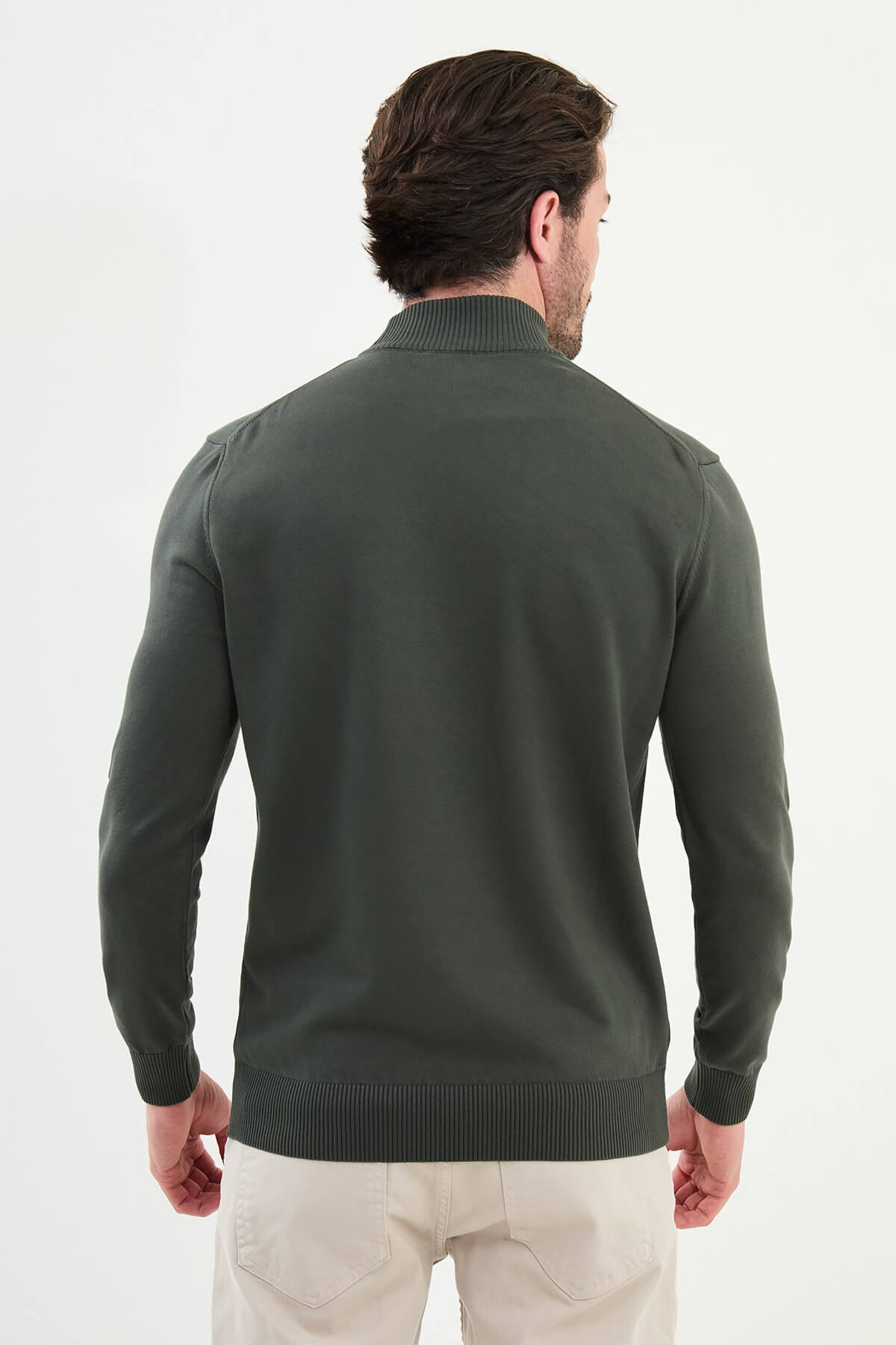 Model in khaki roll neck slim fit sweater paired with beige trousers