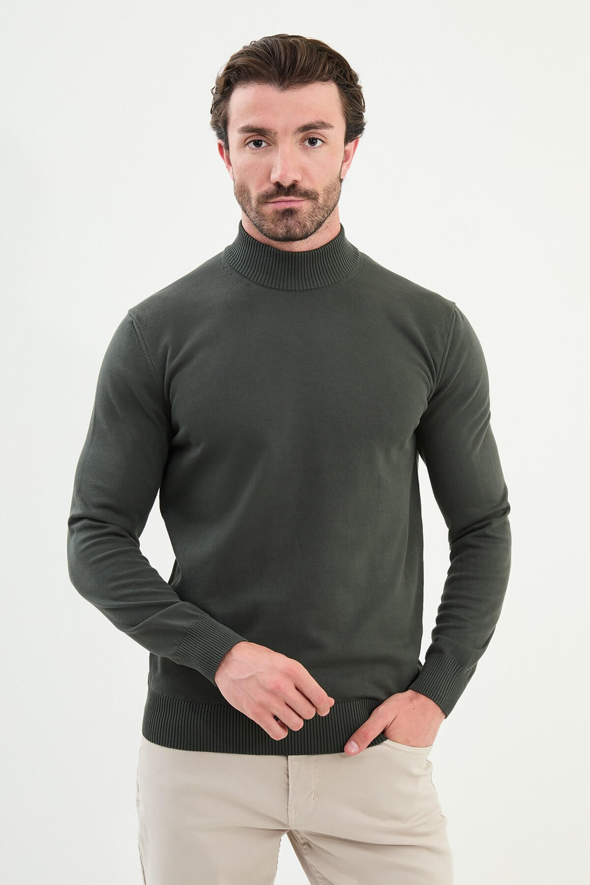 Model in khaki roll neck slim fit sweater paired with beige trousers