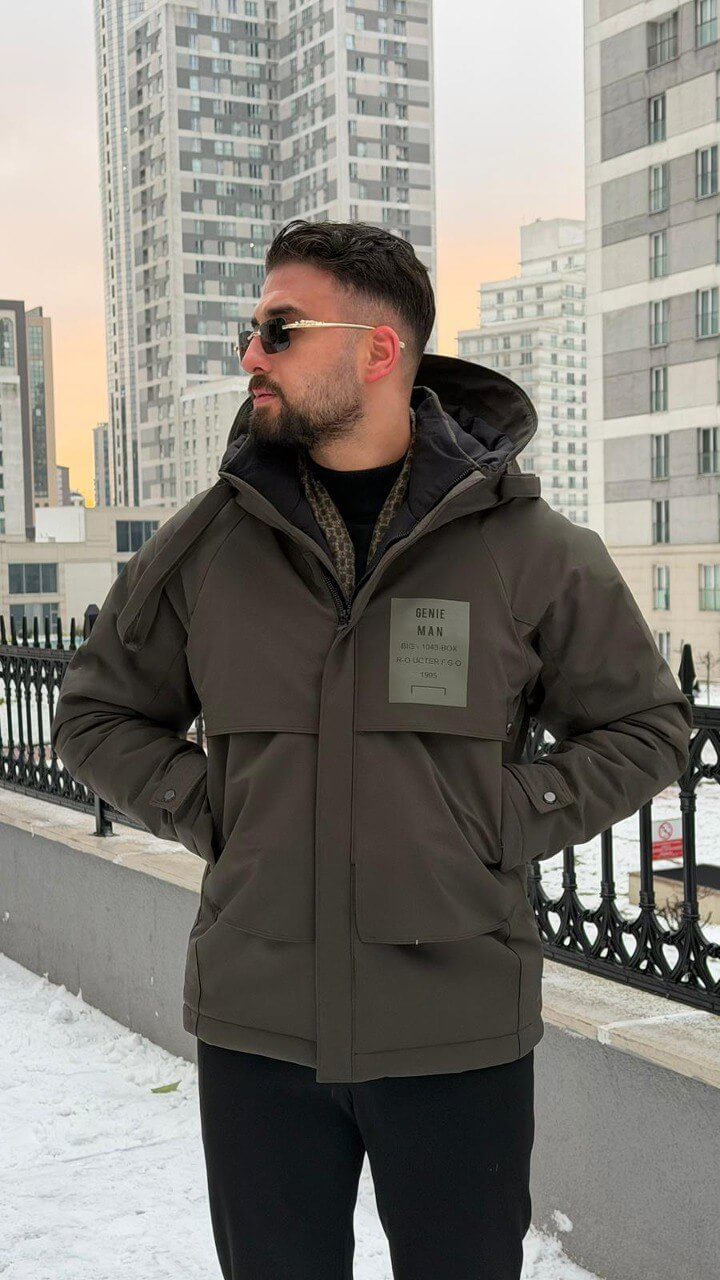 Men’s matte khaki technical winter parka with storm hood and reinforced chin guard, wind-resistant water-repellent polyester shell with stretch, oversized flap pockets and adjustable cuffs, urban commuter outerwear.